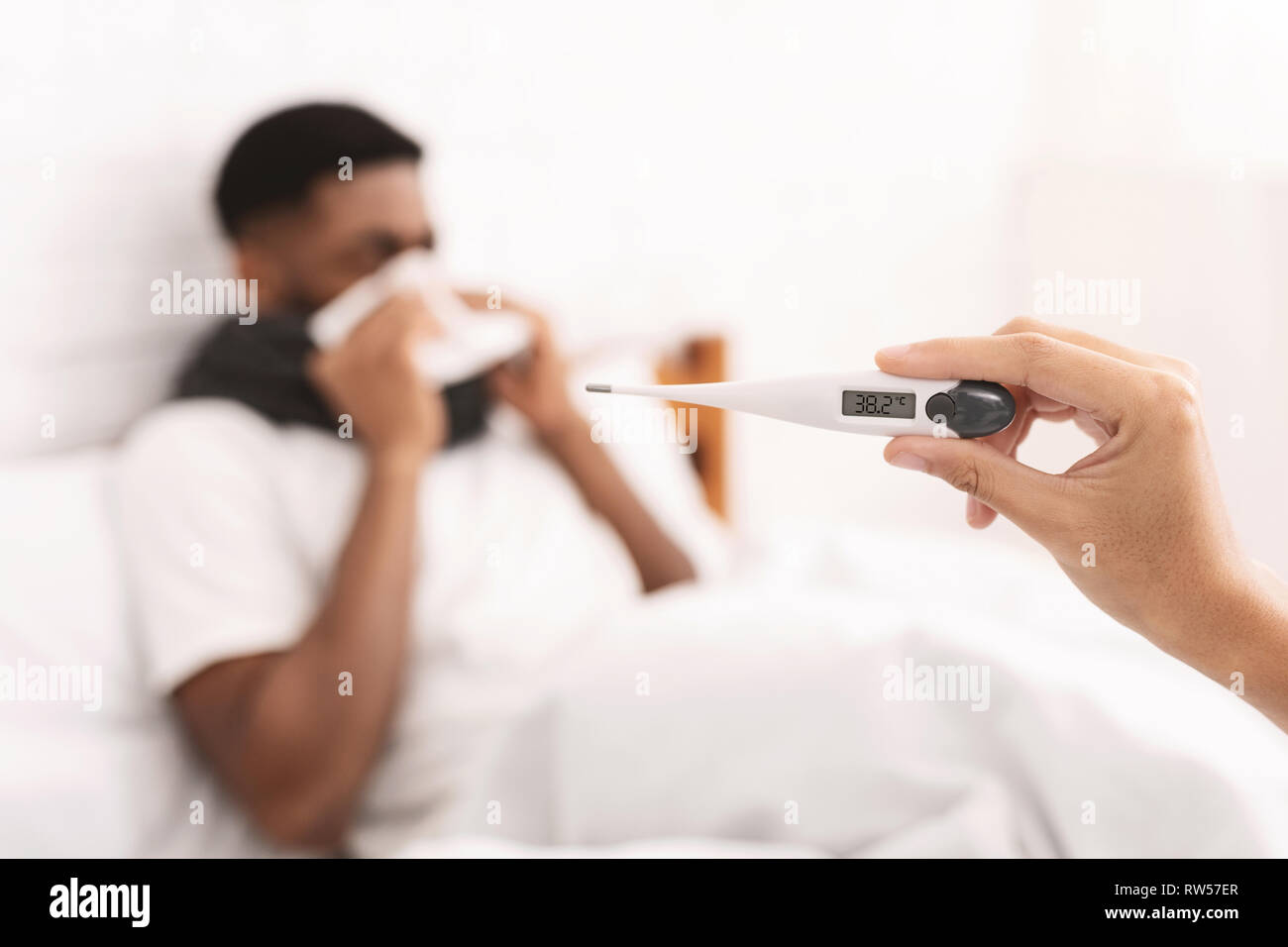 Homme noir malade avec fièvre au lit Banque D'Images