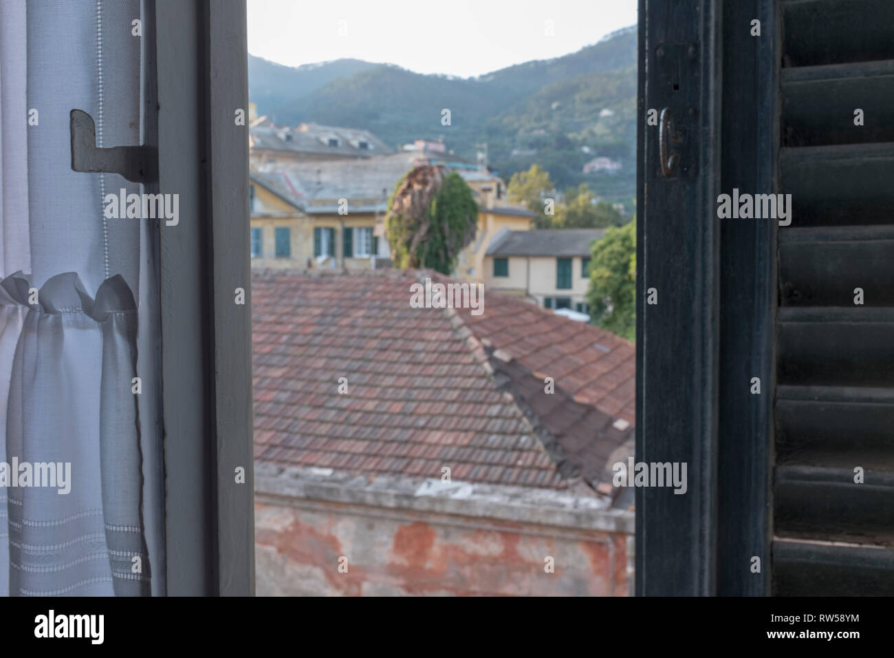Ville italienne vue depuis une demi-fenêtre ouverte avec un volet en bois Banque D'Images