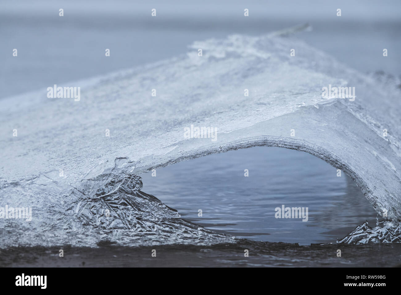 La fonte des glaces et des fissures sur lac gelé et faire un trou dans la glace. Banque D'Images