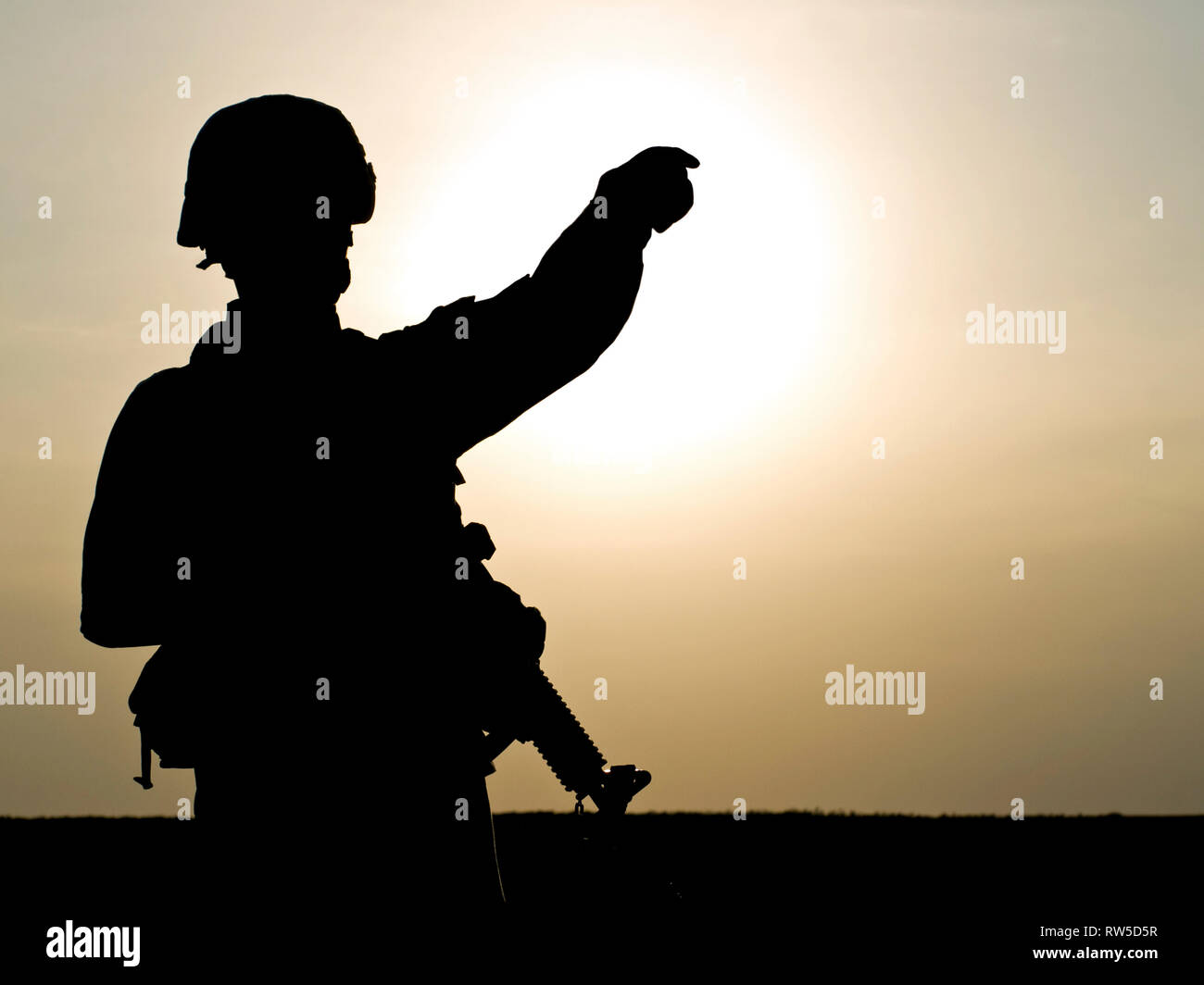 Silhouette de soldat américain au fusil contre un coucher de soleil. Banque D'Images