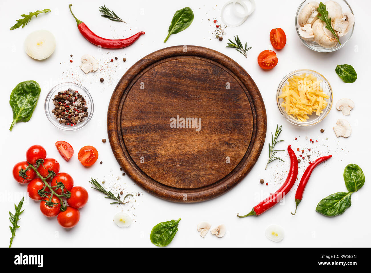 Planche à découper ronde avec ingridients pizza autour de Banque D'Images