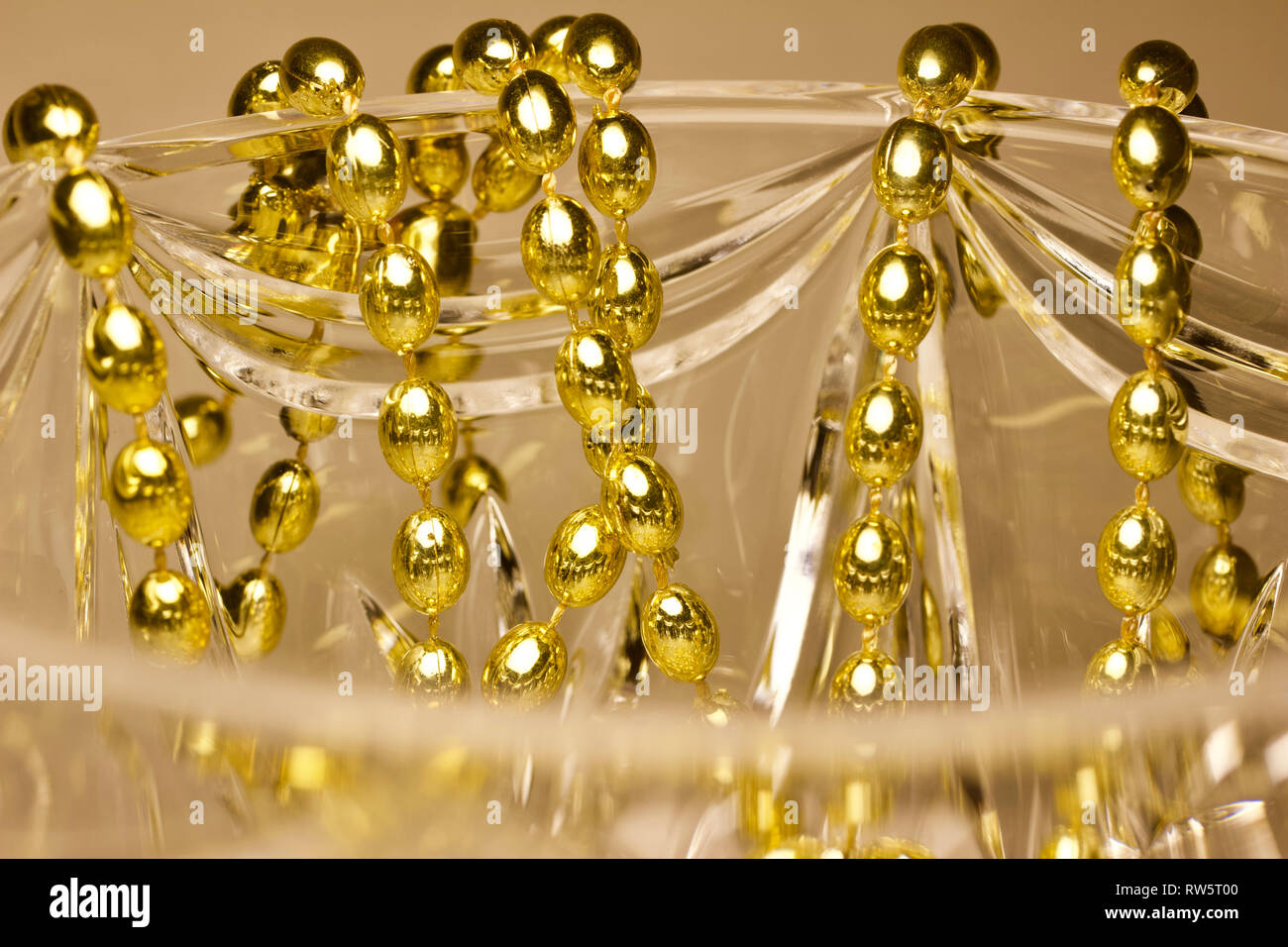 Résumé de macro couleur or perles Mardi Gras drapé sur beau verre en cristal de plomb Banque D'Images