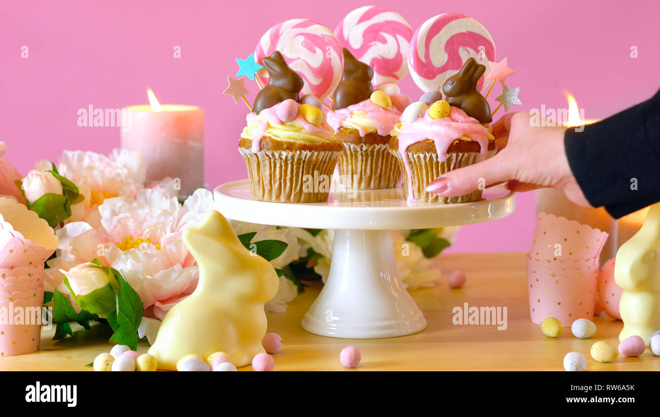 Thème de pâques candy cupcakes égouttoir terre décorée de lapins en chocolat dans la partie table. Banque D'Images