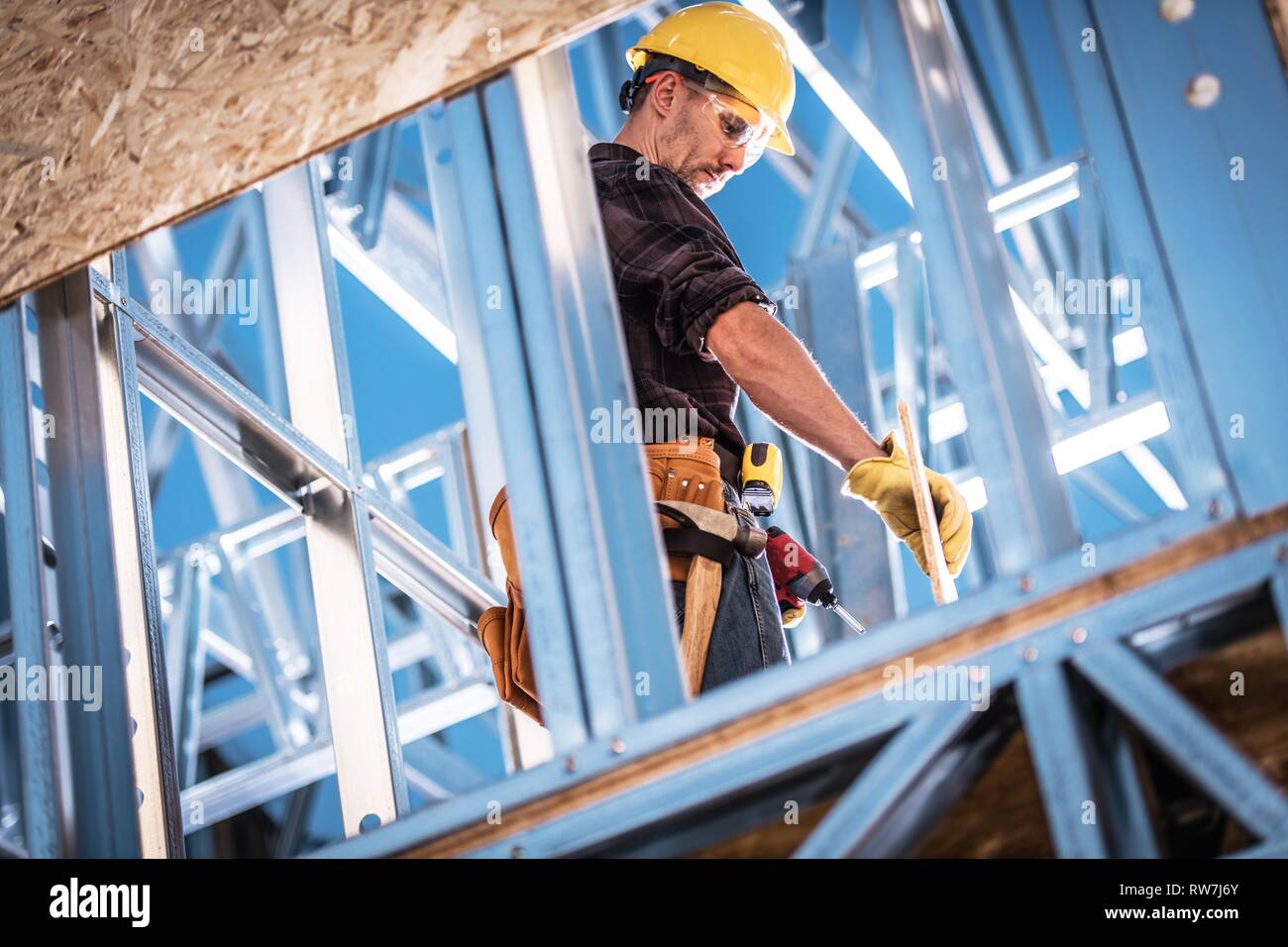 Caucasian Worker et le site de construction. Cadre en acier squelette de l'immeuble. Casque de zone. Banque D'Images