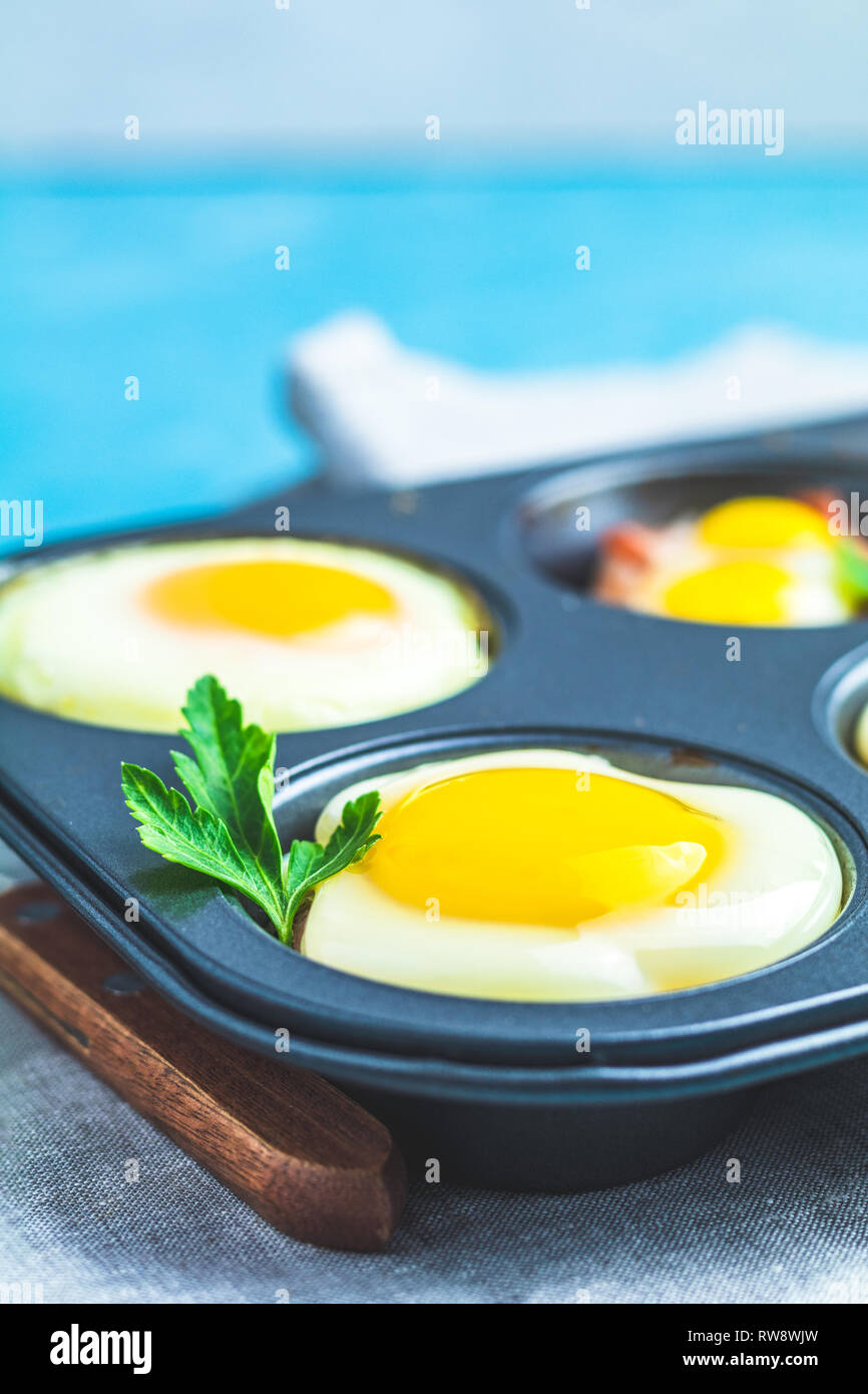 Les œufs cuits dans la cuisson des moules. Cassolette de bacon sowbelly portionné et oeufs dans le style italien. Banque D'Images