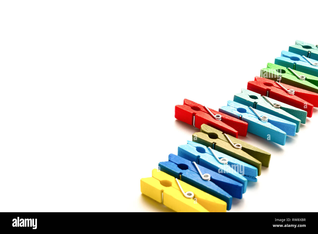 Pinces à linge en bois coloré avec un bâton sur un fond blanc Banque D'Images