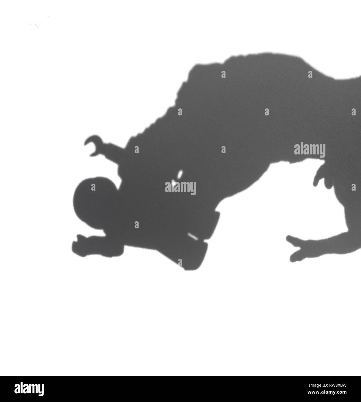 Ombre d'un tyrannosaurus mordant un corps humain sur blanc aucun logo ou marque déposée Banque D'Images