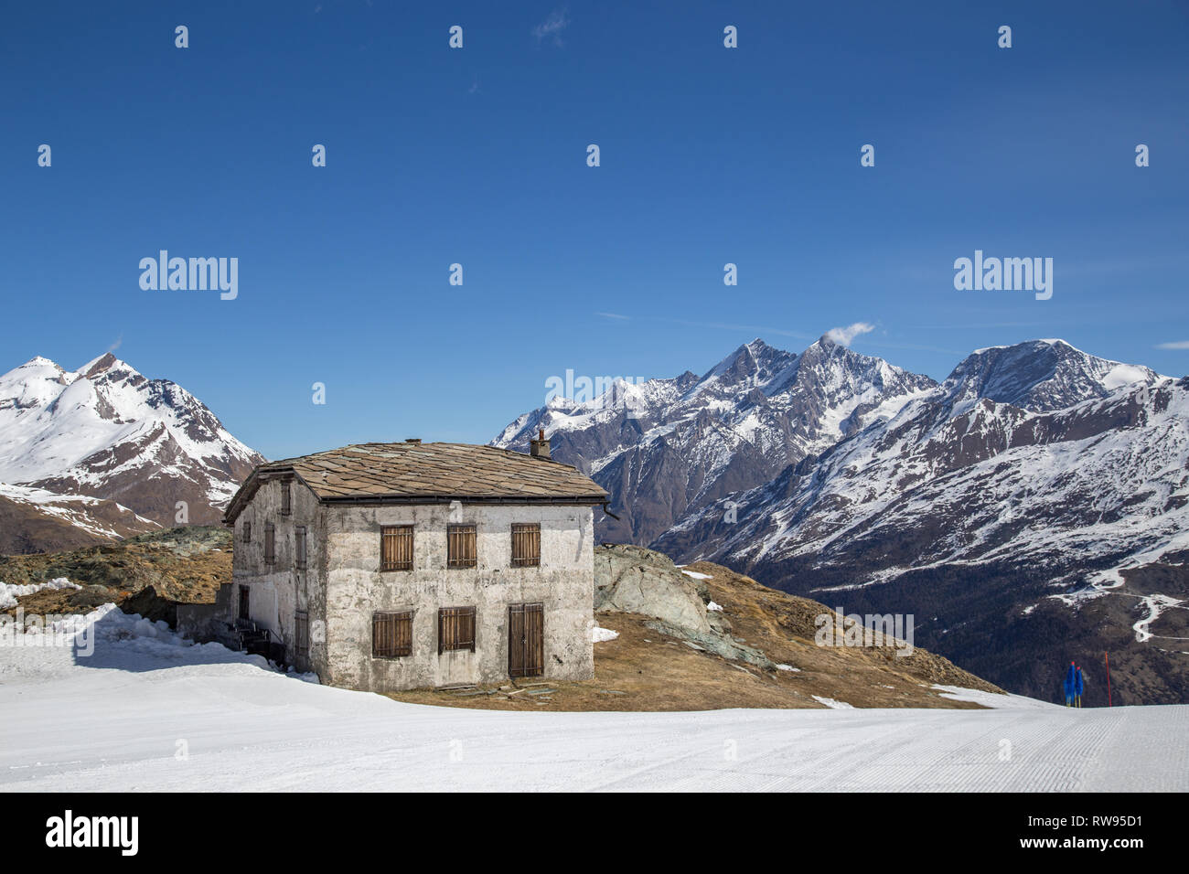 Cabane en pierre dans les montagnes suisses enneigées Banque D'Images