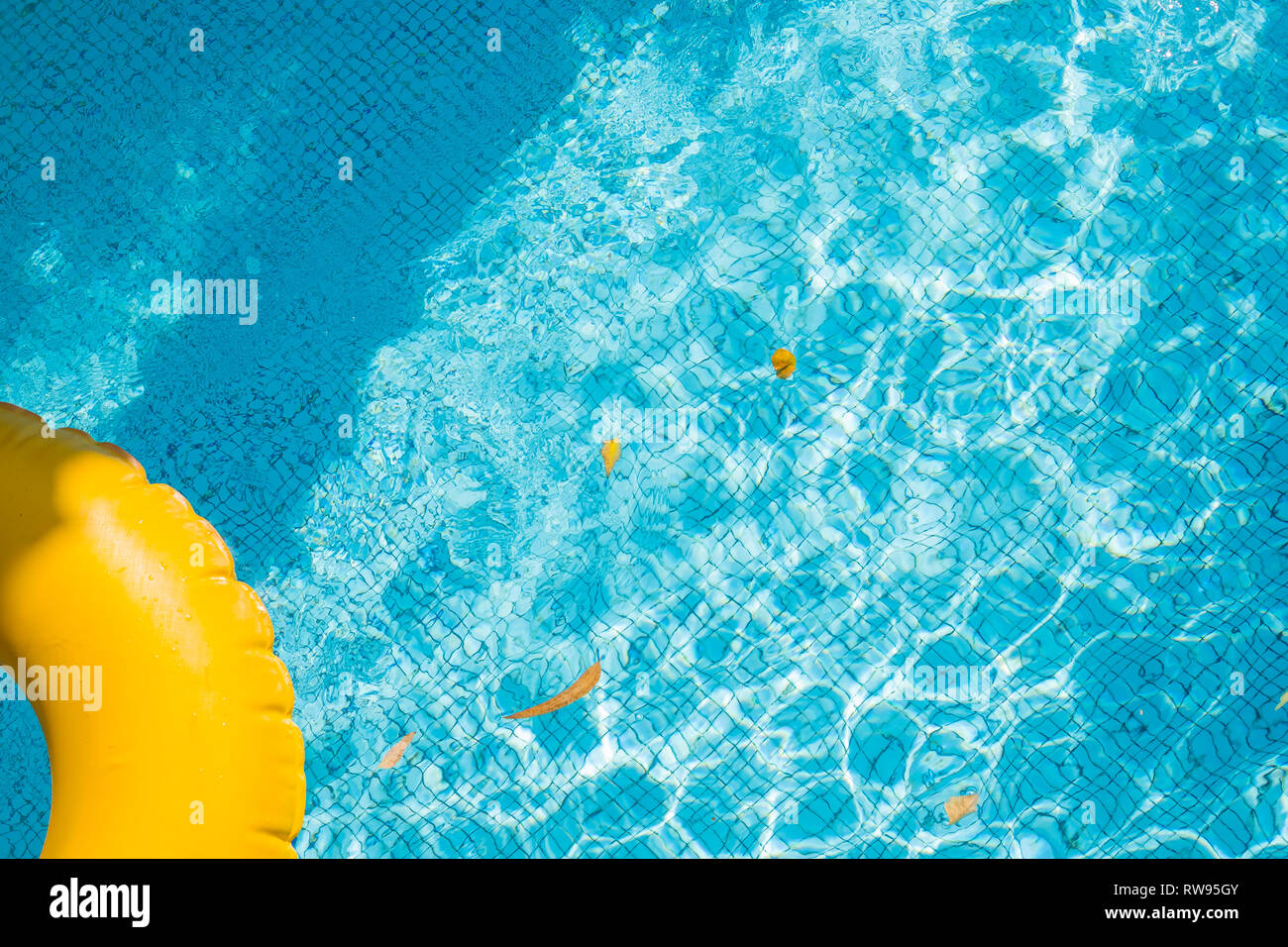 Anneau flottant sur l'eau bleu swimpool avec des vagues se reflétant dans le soleil de l'été. Lazy river.L'eau extérieure avec piscine jaune bague flottante.les vacances d'été ou Banque D'Images