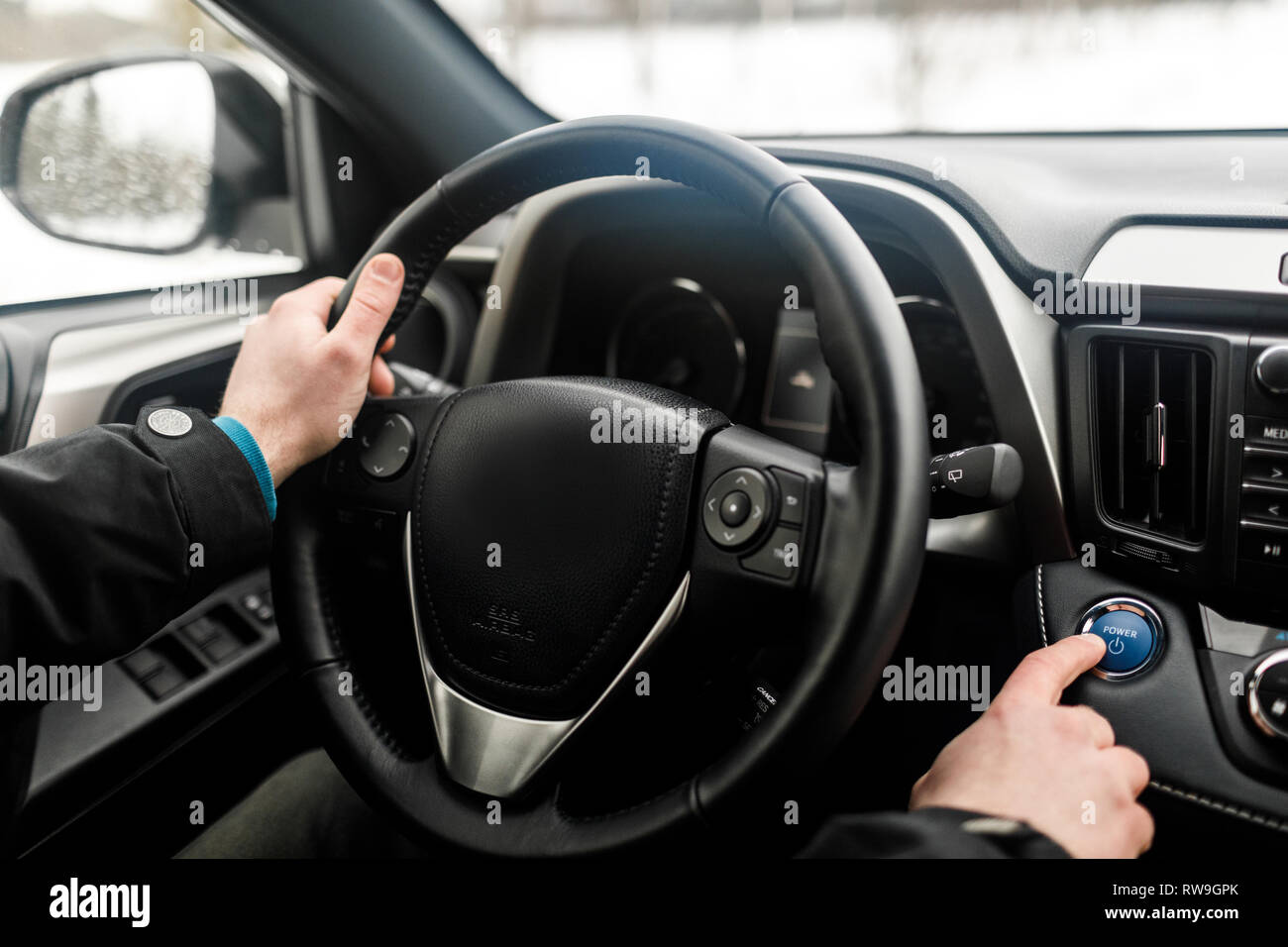 Moteur de voiture pilote en poussant le bouton start-stop en voiture moderne. Banque D'Images