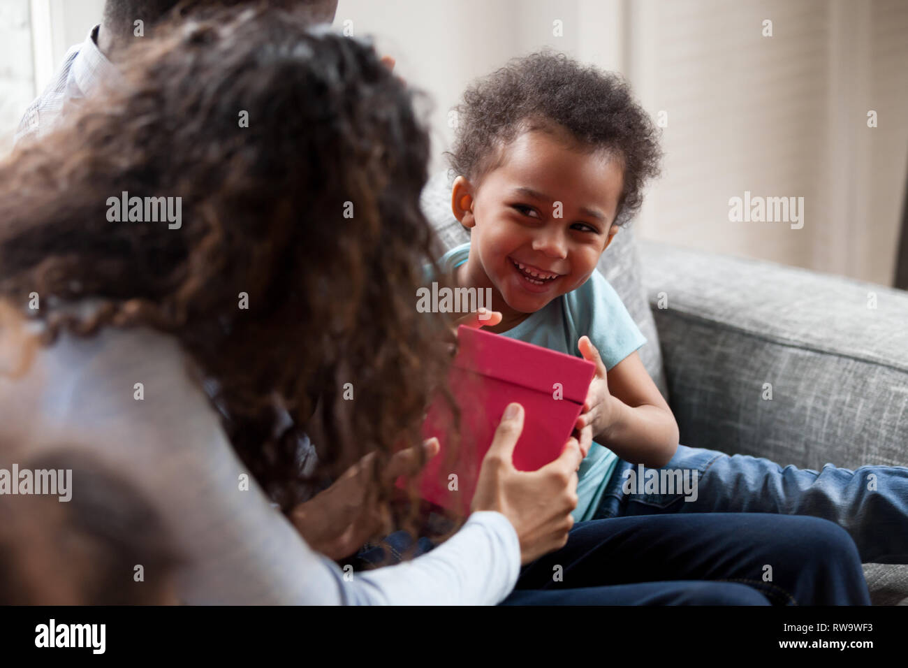 Drôle enfant noir donner fort rendre présente à la maman Banque D'Images