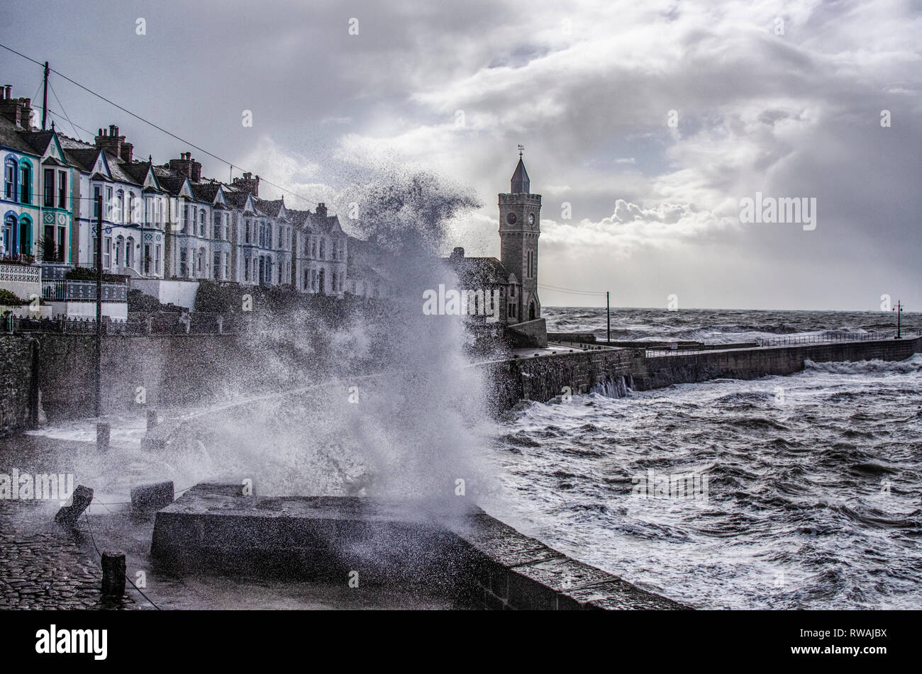 Tour de l'horloge de Porthleven avec s'écraser les vagues de tempête Banque D'Images