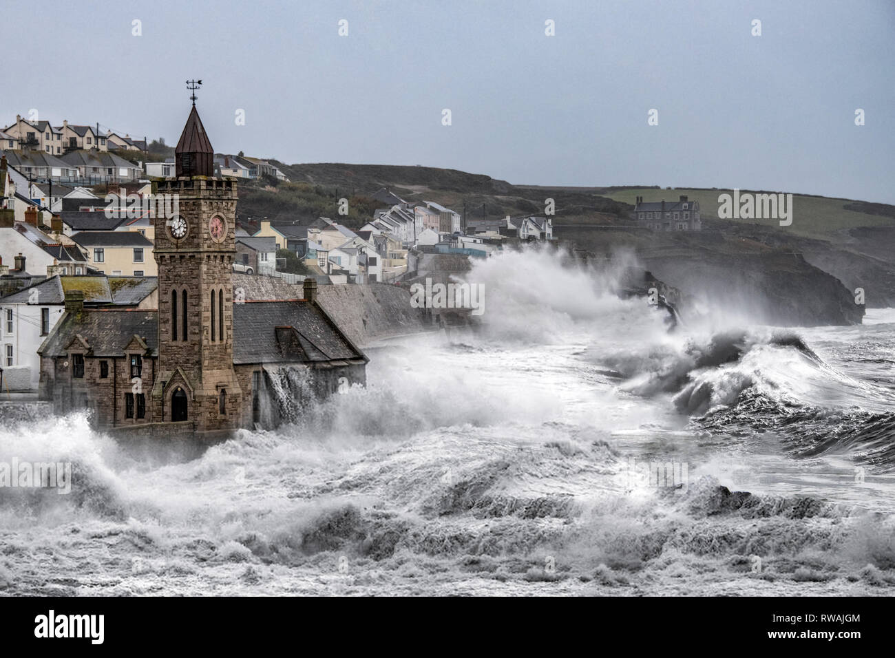 Tour de l'horloge de Porthleven avec s'écraser les vagues de tempête, énorme vagues générées par les tempêtes d'hiver a frappé la côte de Cornouailles à Porthleven Harbour Banque D'Images