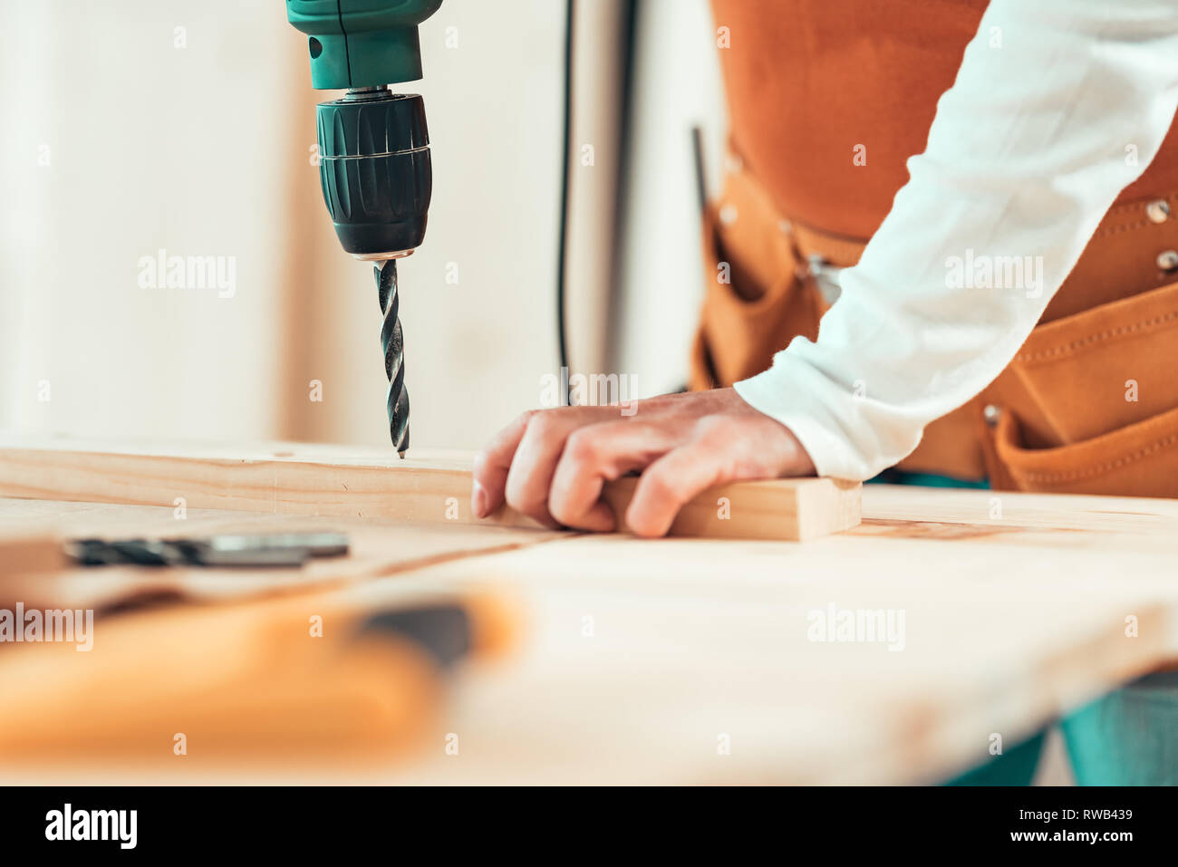 Female carpenter en utilisant la perceuse électrique en atelier de menuiserie ébénisterie, selective focus Banque D'Images