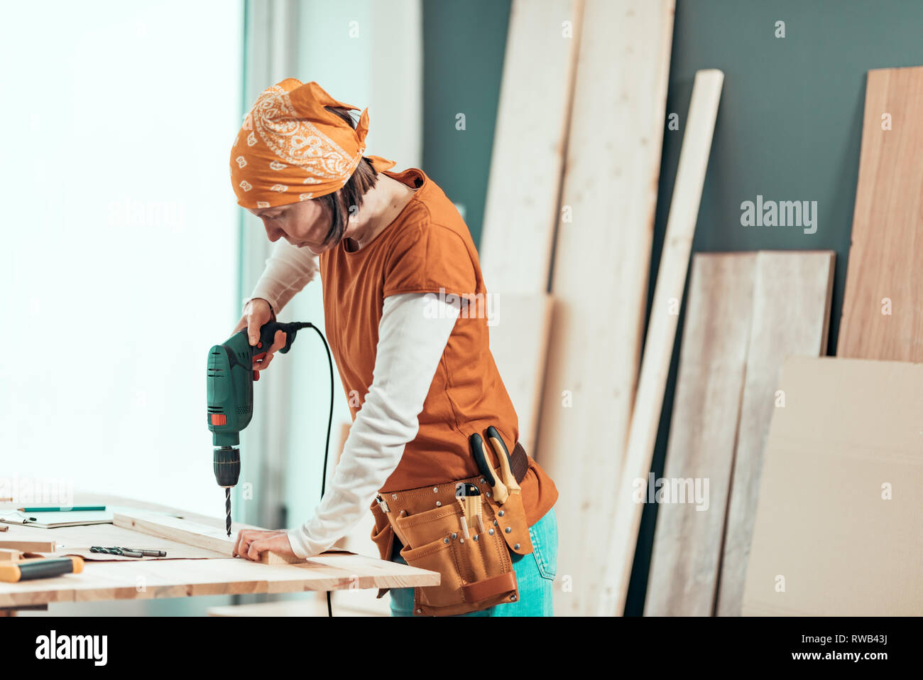 Female carpenter en utilisant la perceuse électrique en atelier de menuiserie ébénisterie, selective focus Banque D'Images