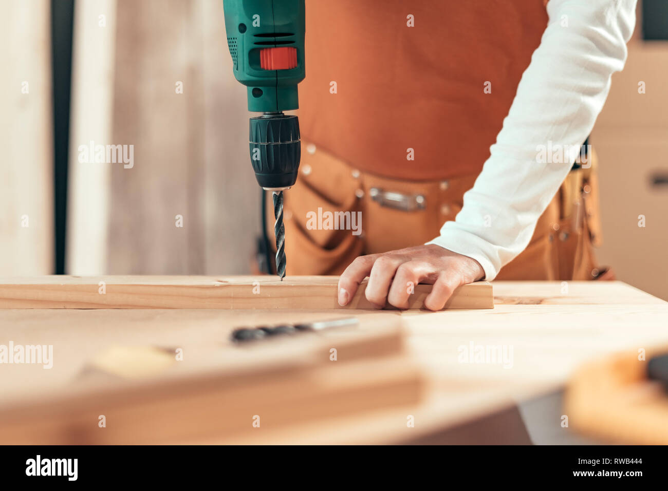 Female carpenter en utilisant la perceuse électrique en atelier de menuiserie ébénisterie, selective focus Banque D'Images