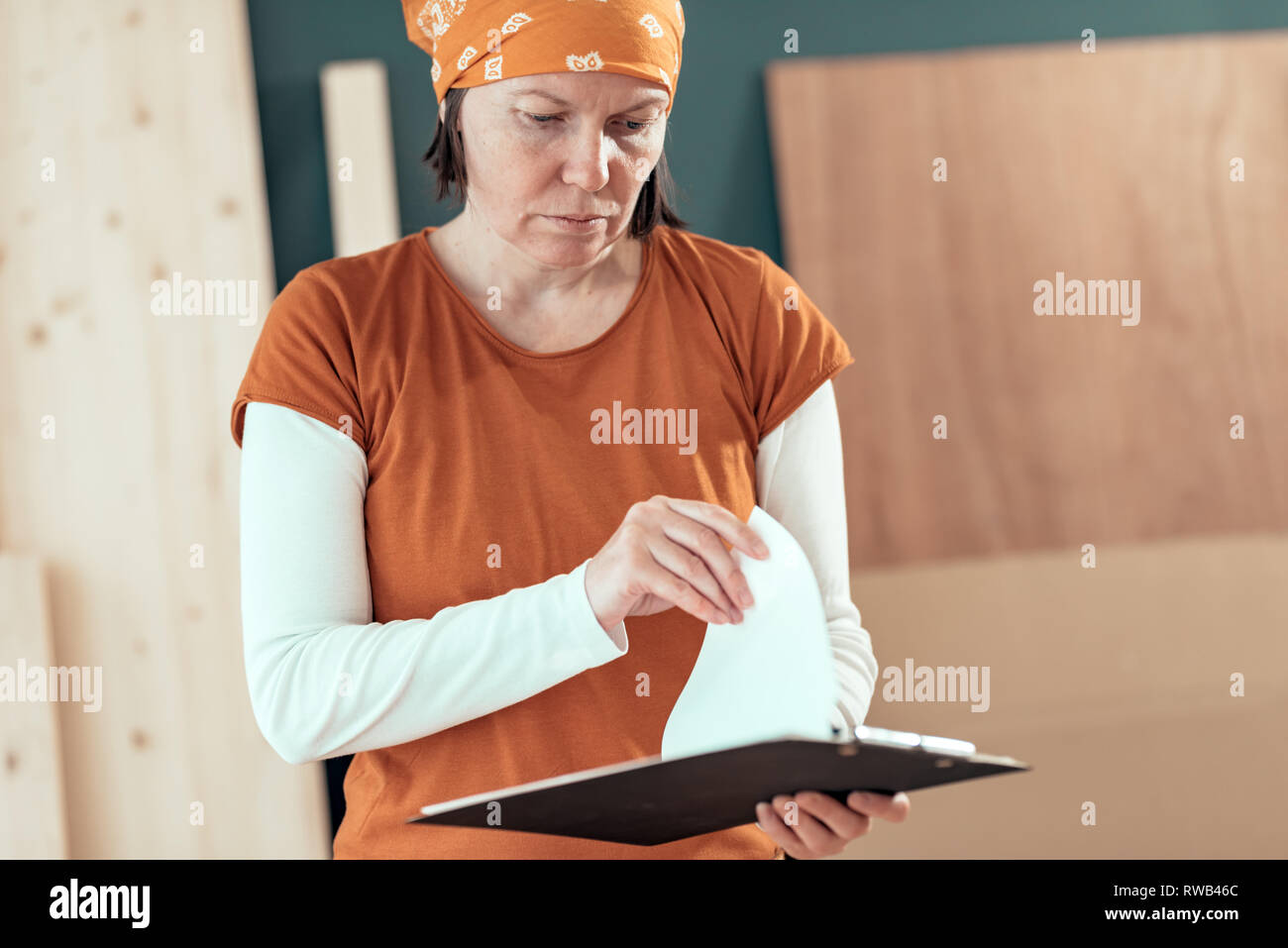 Female carpenter lecture Projet de bricolage Note dans la petite entreprise atelier de menuiserie Banque D'Images