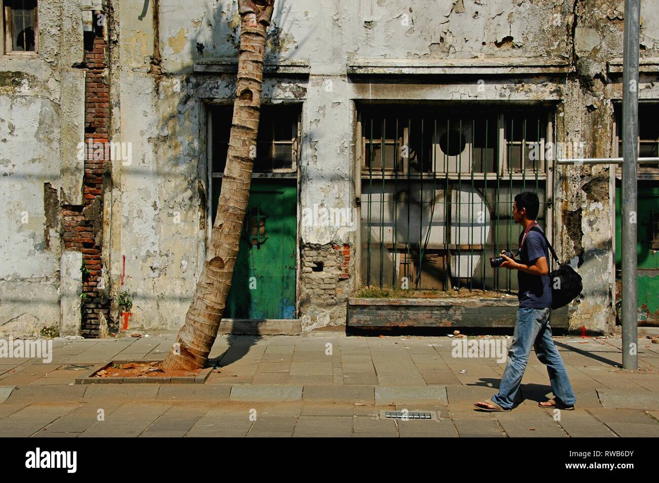 Un photographe masculin marche dans les rues de Kota Tua Jakarta, Indonésie. Banque D'Images