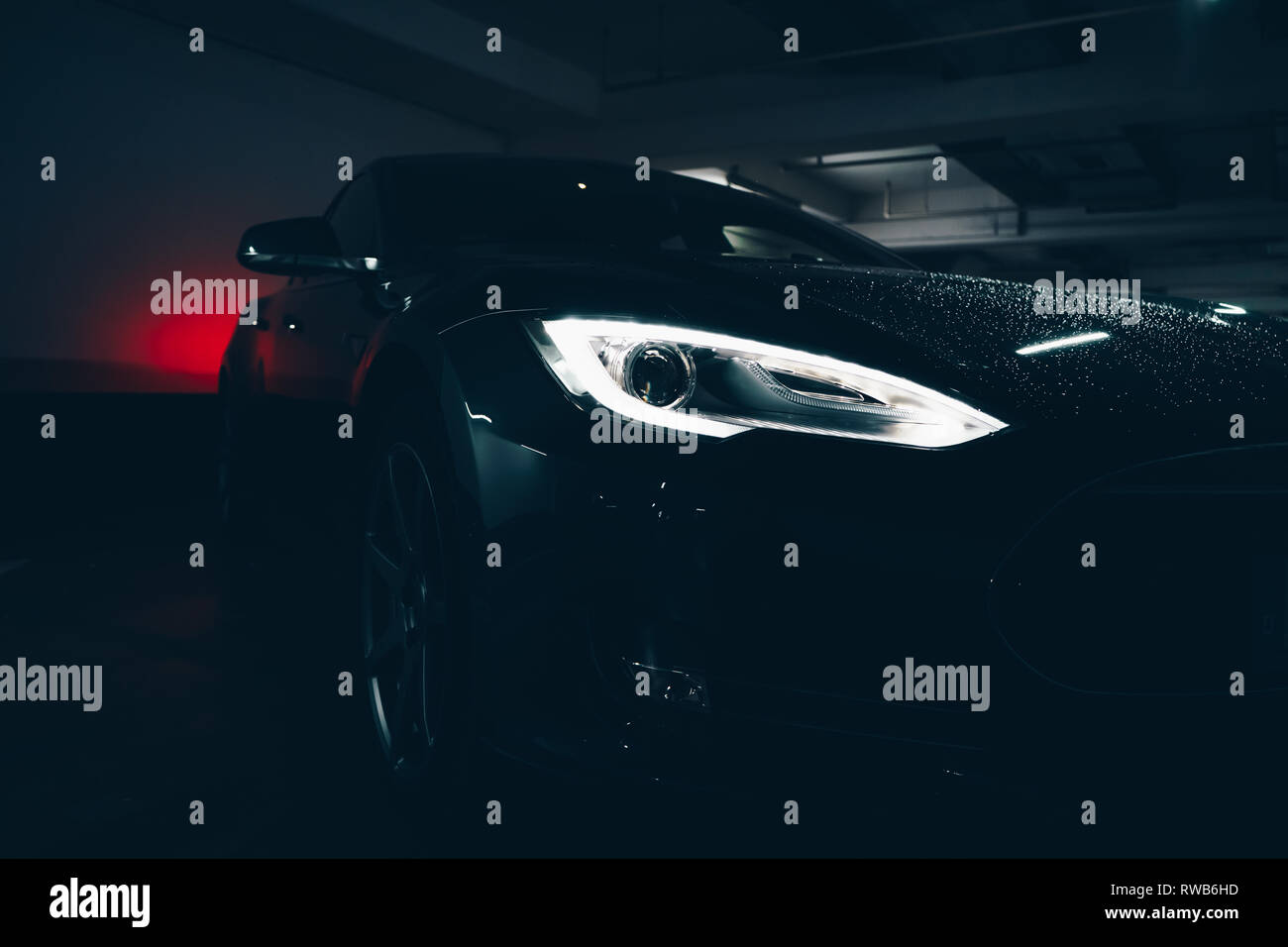 Dans cette image, vous trouverez une belle Tesla Model S dans un parking souterrain. Banque D'Images
