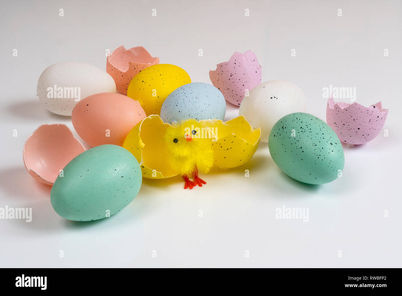 Œufs de Pâques colorés avec des petits poussins sur une surface blanche Banque D'Images