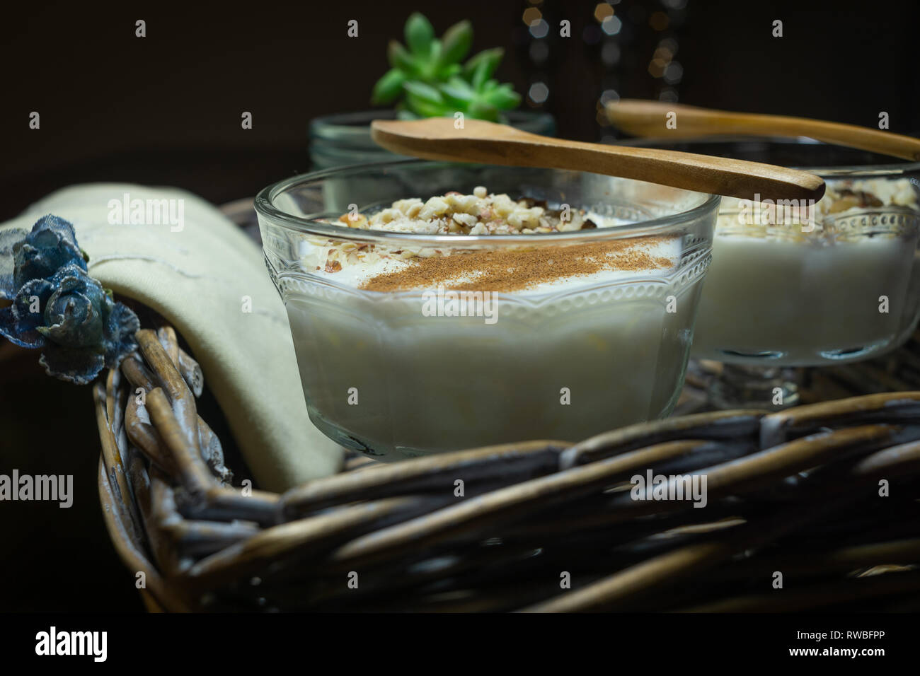 Riz au lait servi dans des tasses en verre. Décoré. Close-up. Dessert Maison décorée avec des serviettes à la main dans un bac en osier Banque D'Images