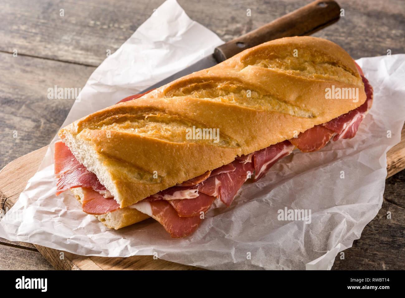 Sandwich au jambon serrano espagnol sur table en bois. Banque D'Images