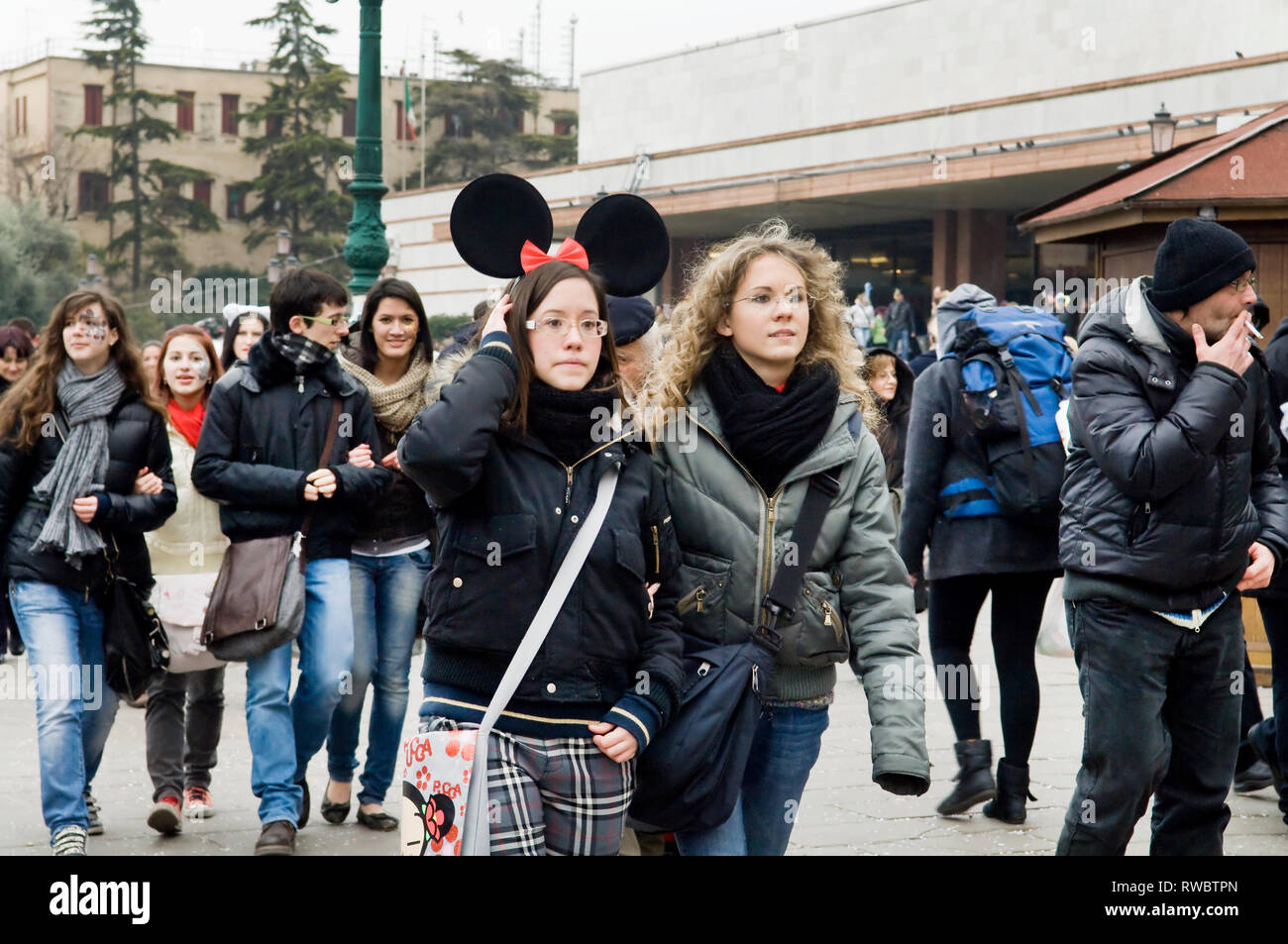 Des groupes de personnes marchant autour pendant le week-end du carnaval de Venise, Italie. Femme portant centrale Micky Mouse ears Banque D'Images