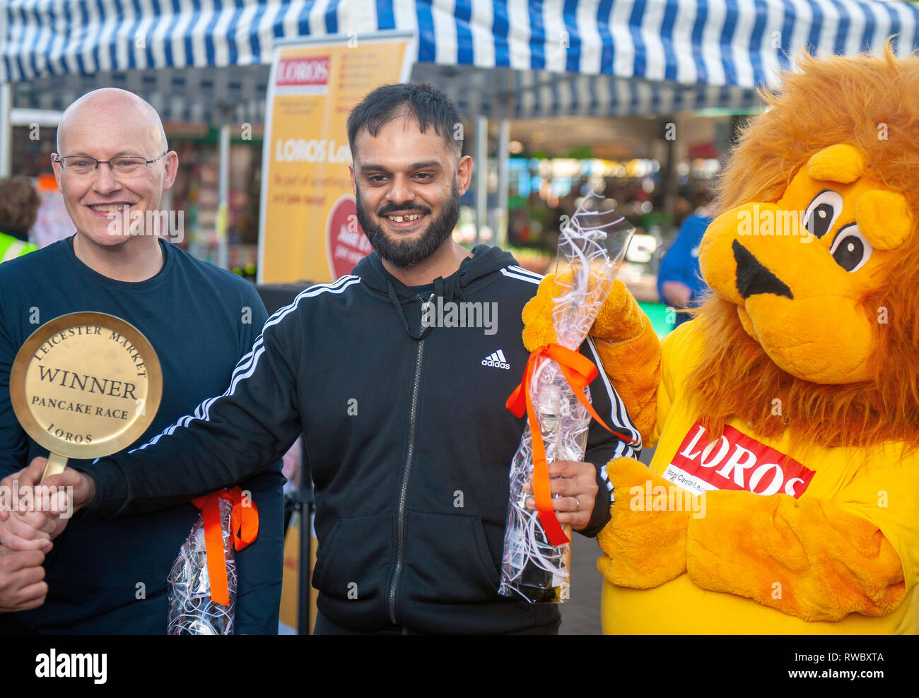 Mardi Gras annuel pancake race autour de Leicester dans le marché de l'aide de bienfaisance Hospice LOROS. Banque D'Images