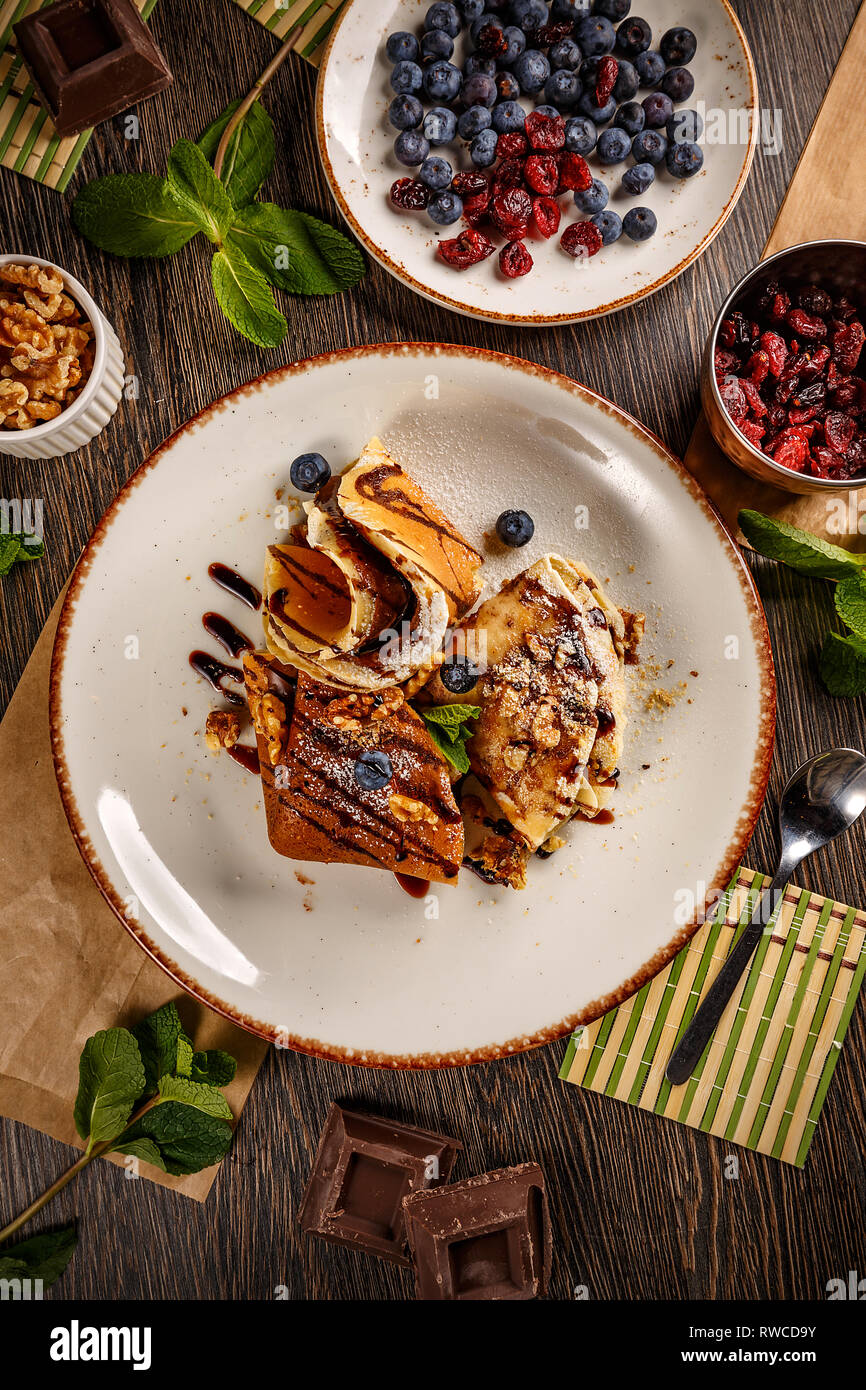 Des crêpes avec du chocolat à tartiner et les noix. Crêpes minces faits maison pour le dessert Banque D'Images