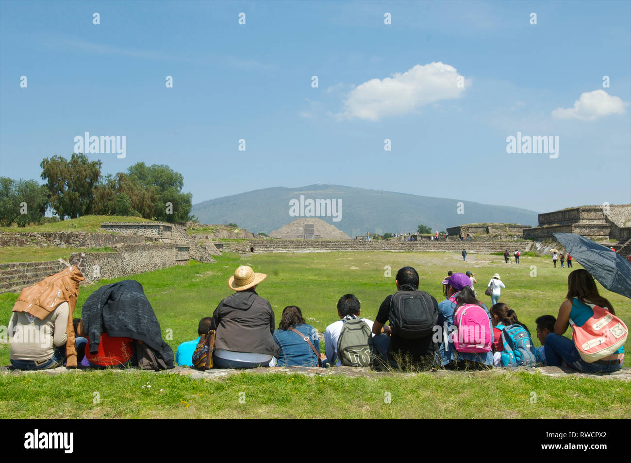 Vue sur la Pyramide du soleil et de personnes à pied et reposant sur l'Avenue des Morts avec les touristes à Teotihuacan, Mexique Banque D'Images