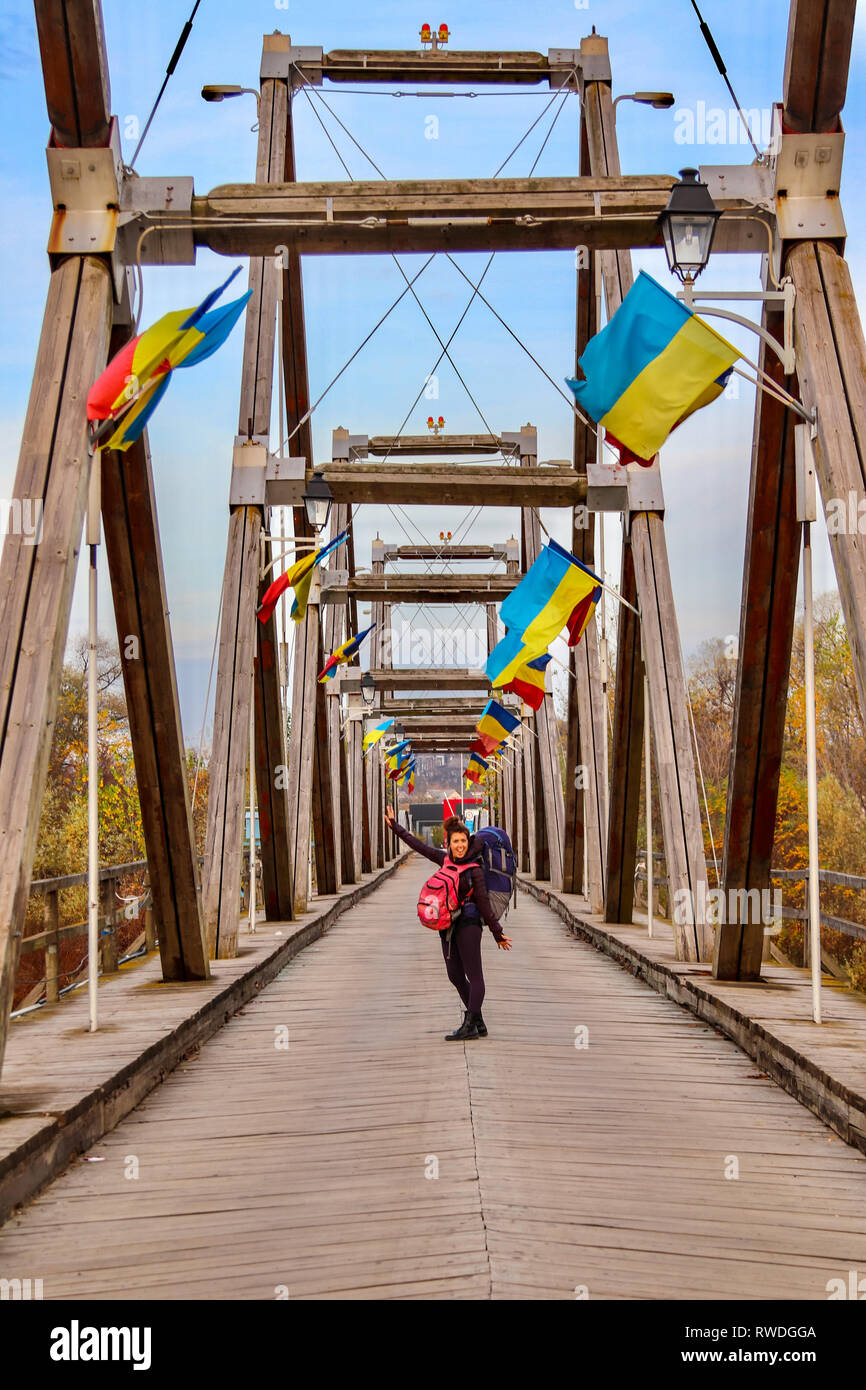 Backpacker féminin se rend sur un pont à la frontière de la Roumanie à l'Ukraine Banque D'Images