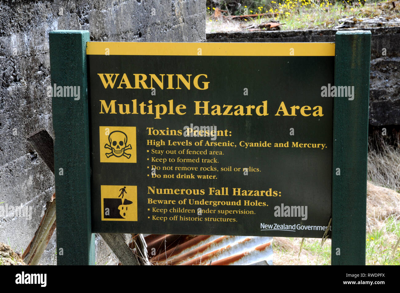 Avis de danger et d'une clôture constituée par l'Deapoartment de Conservation (DOC) à l'ancien site de traitement d'or de la batterie de la rivière Snowy, Waiuta. Banque D'Images