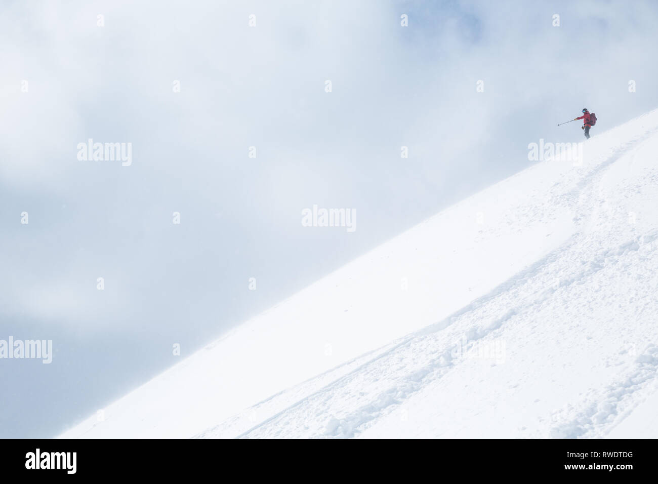 La skieuse de l'arrière-pays dans le Japon fait observer sa ligne vers le bas d'une pente de poudre à Hokkaido près de Niseko Mountain. Banque D'Images