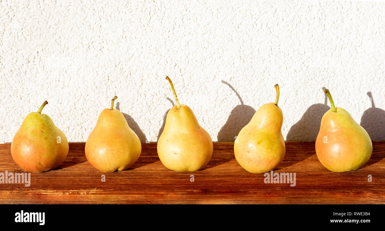 Poires mûres dans la ligne droite. Composition extérieur lumineux au soleil Banque D'Images