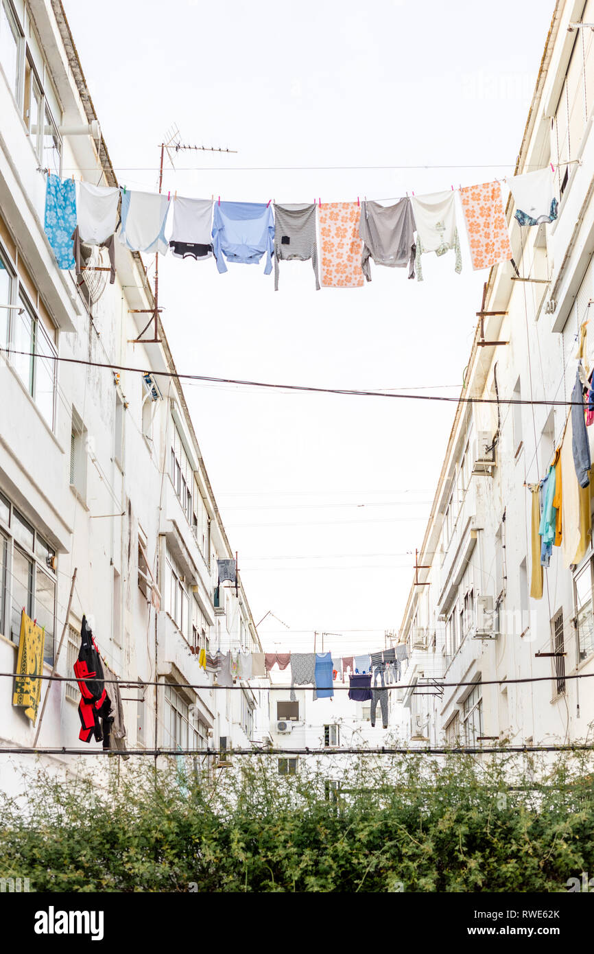 Vêtements lavés accroché entre bâtiments residencial à Ayamonte, Andalousie, Espagne Banque D'Images