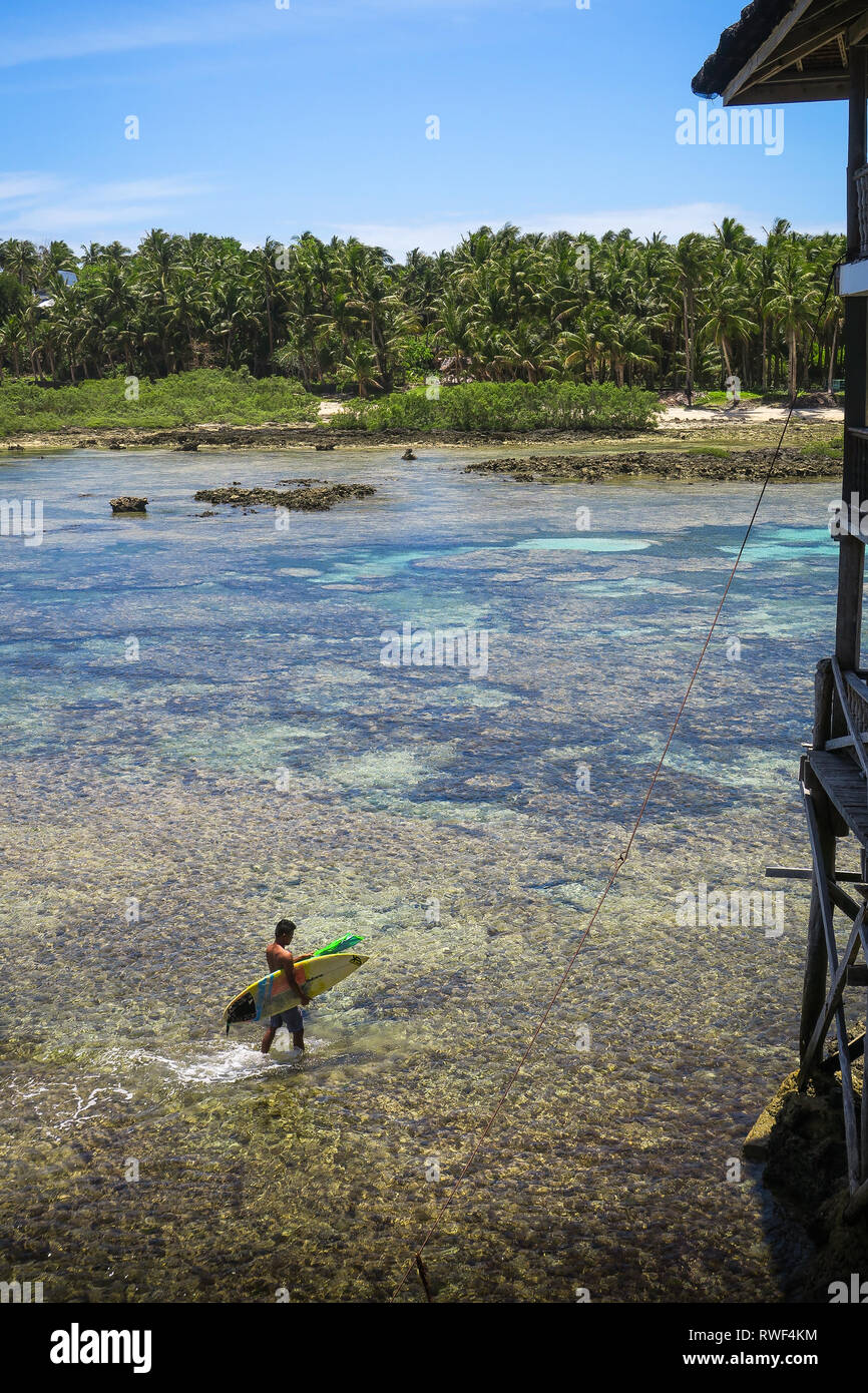 Surfer Walking on Beach with Surfboard - Cloud 9 Boardwalk - Siargao, Philippines Banque D'Images