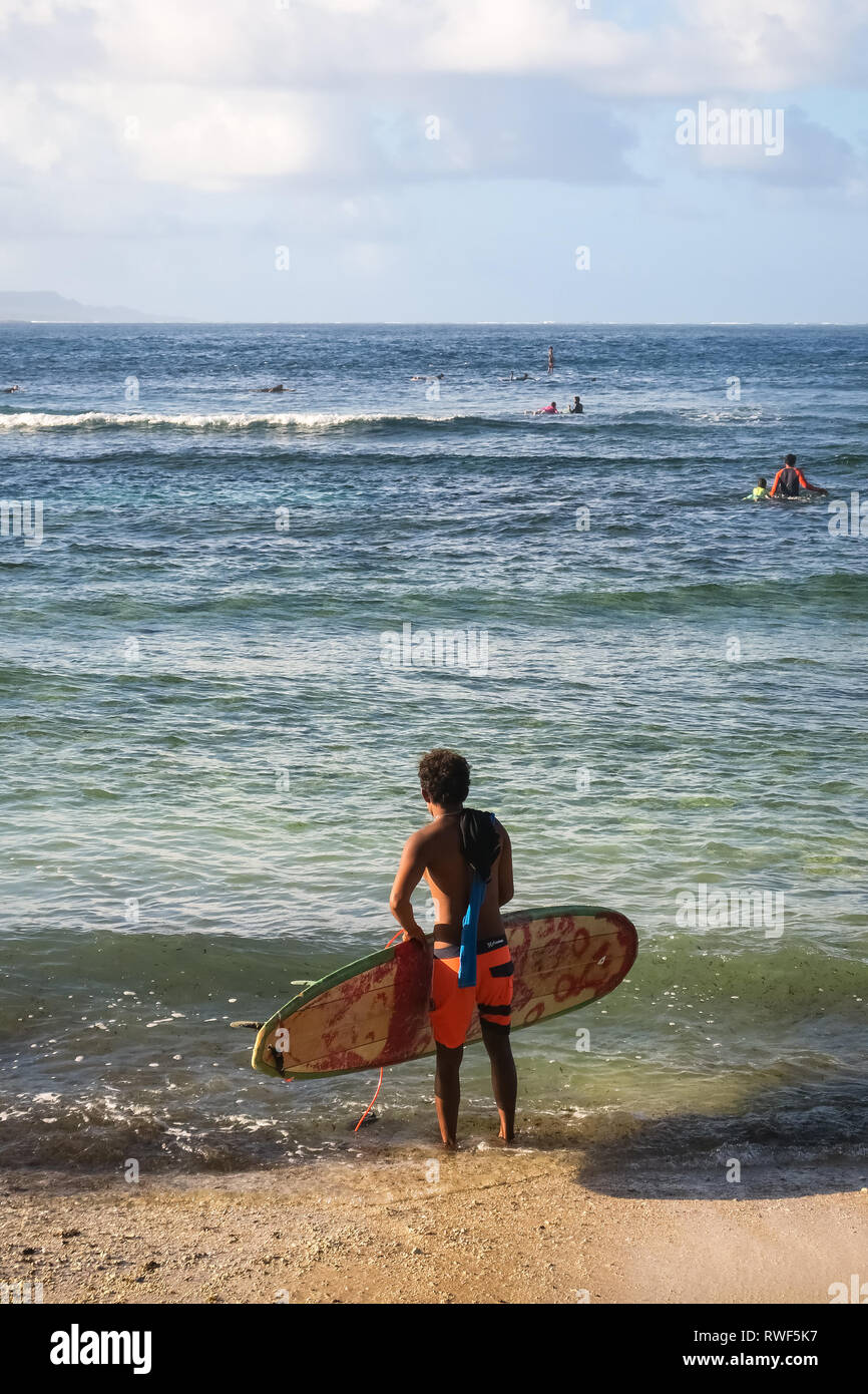 Guy Standing surfer sur la plage, regarder les vagues - Cloud 9 - Philippines Siargao, Banque D'Images