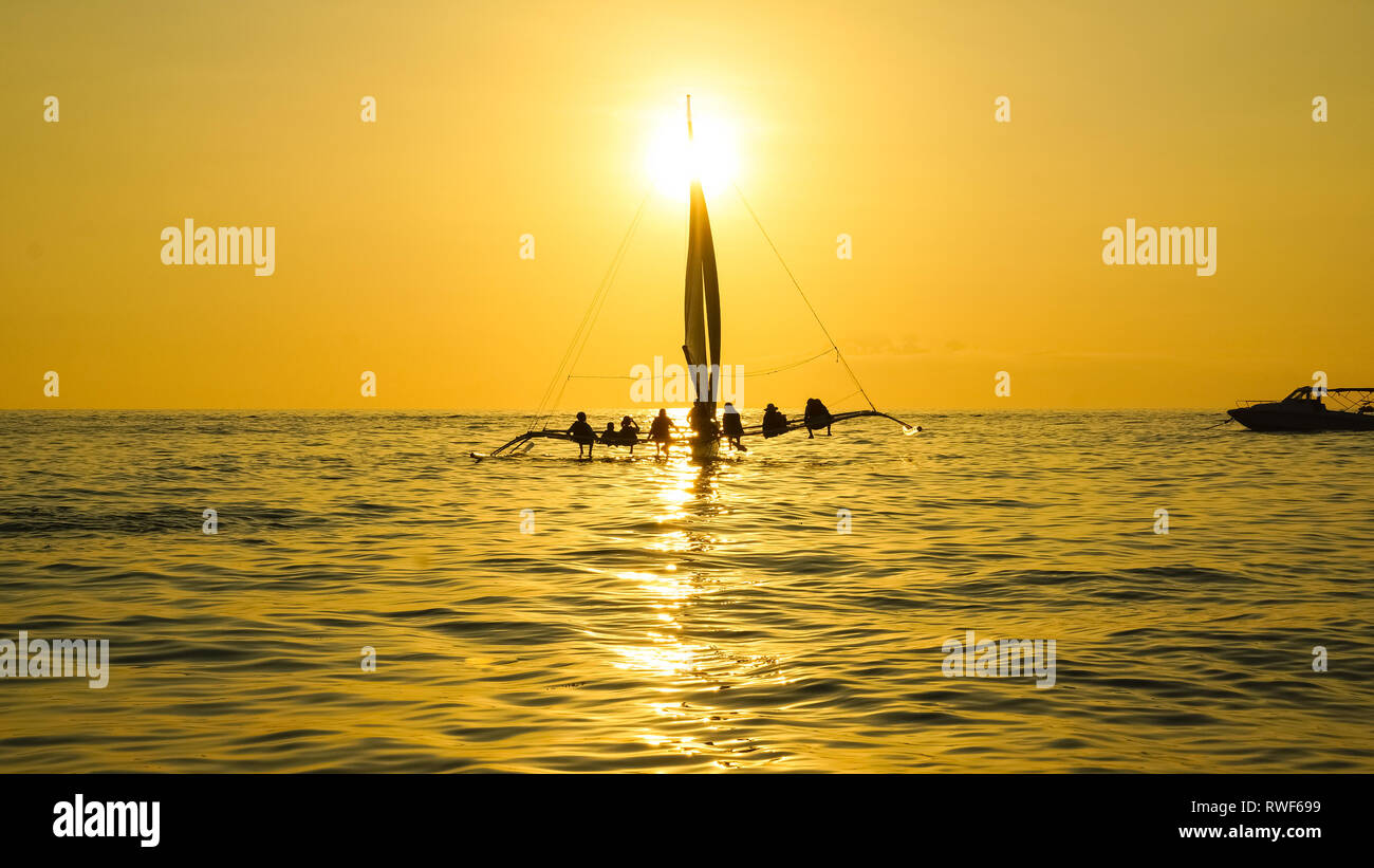 Voilier avec les touristes assis sur la mer au coucher du soleil d'Or - l'île de Boracay, Philippines - Panay Banque D'Images