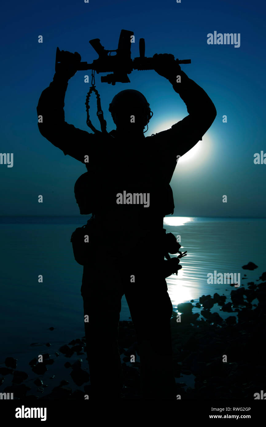 Silhouette de soldat de l'armée américaine avec son fusil au-dessus de nuit avec la lune. Banque D'Images