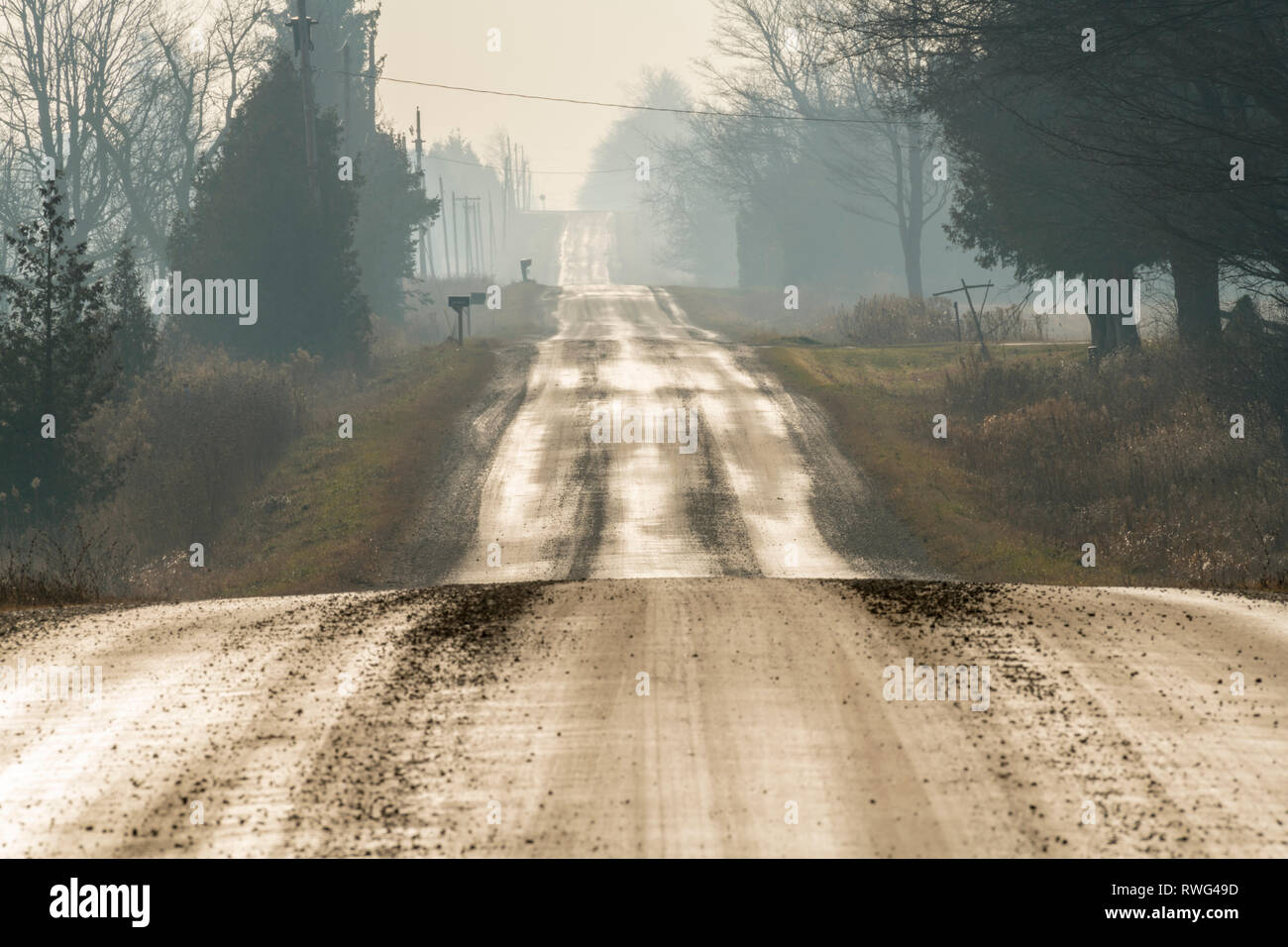 Une route de gravier, rural humide au début de décembre, nr Grand Valley, en Ontario, Canada Banque D'Images