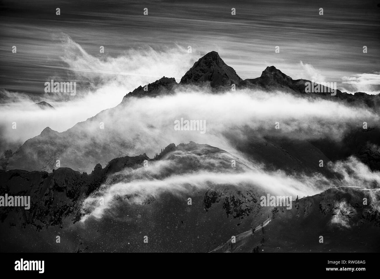 Mont Harlow avec voile de nuages en noir et blanc dans la chaîne de montagnes de Valhalla, BC, Canada, Hiver Banque D'Images
