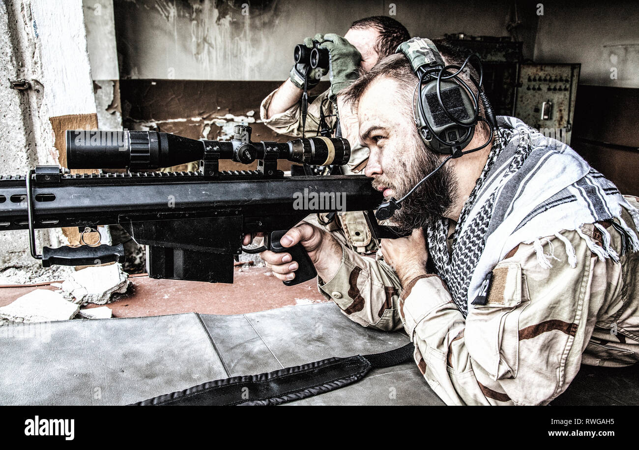 Joint Marine de l'équipe de tireurs d'engager des objectifs d'un bâtiment en ruine avec un fusil de sniper. Banque D'Images