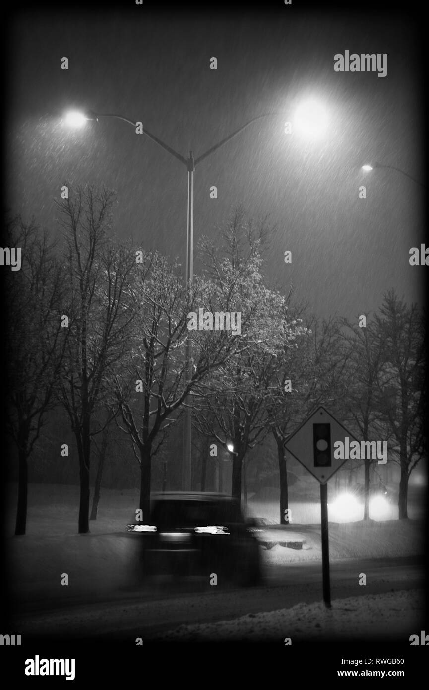 La neige qui tombe sur une rue déserte la nuit en banlieue de Toronto Banque D'Images