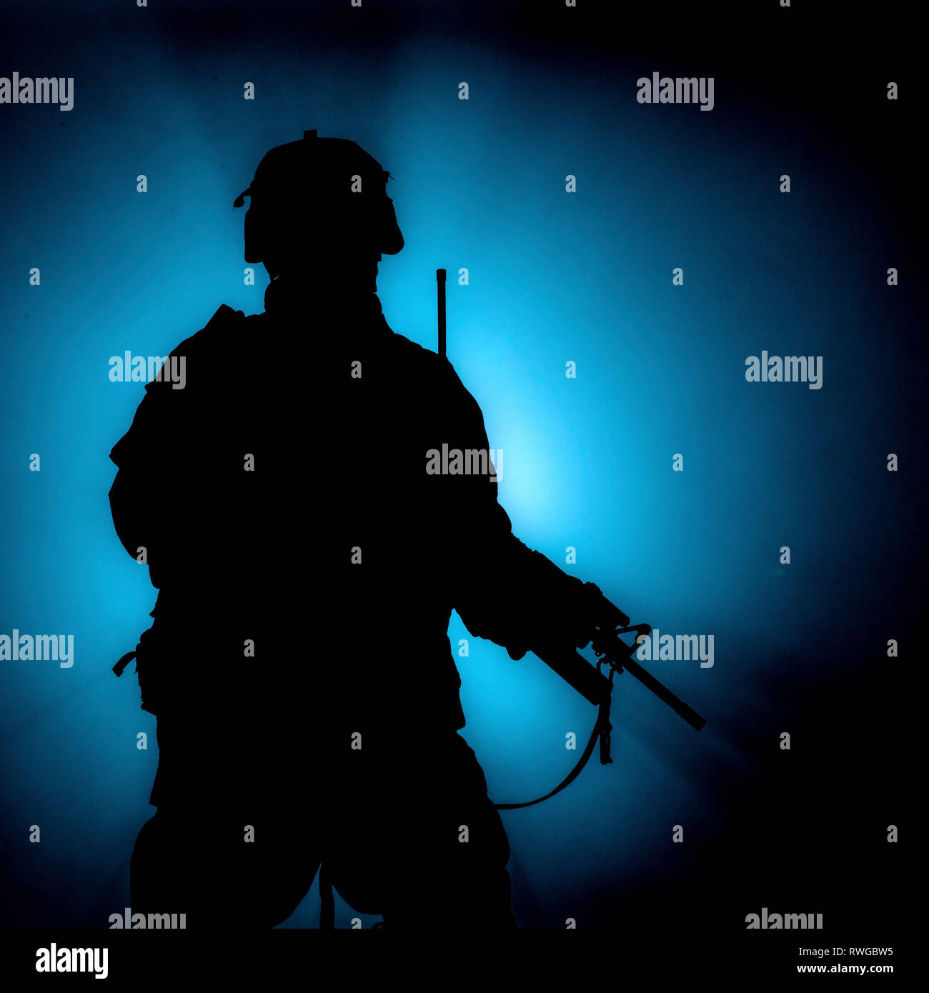 Silhouette de soldat d'infanterie moderne debout avec fusil d'assaut sur fond de couleur. Banque D'Images