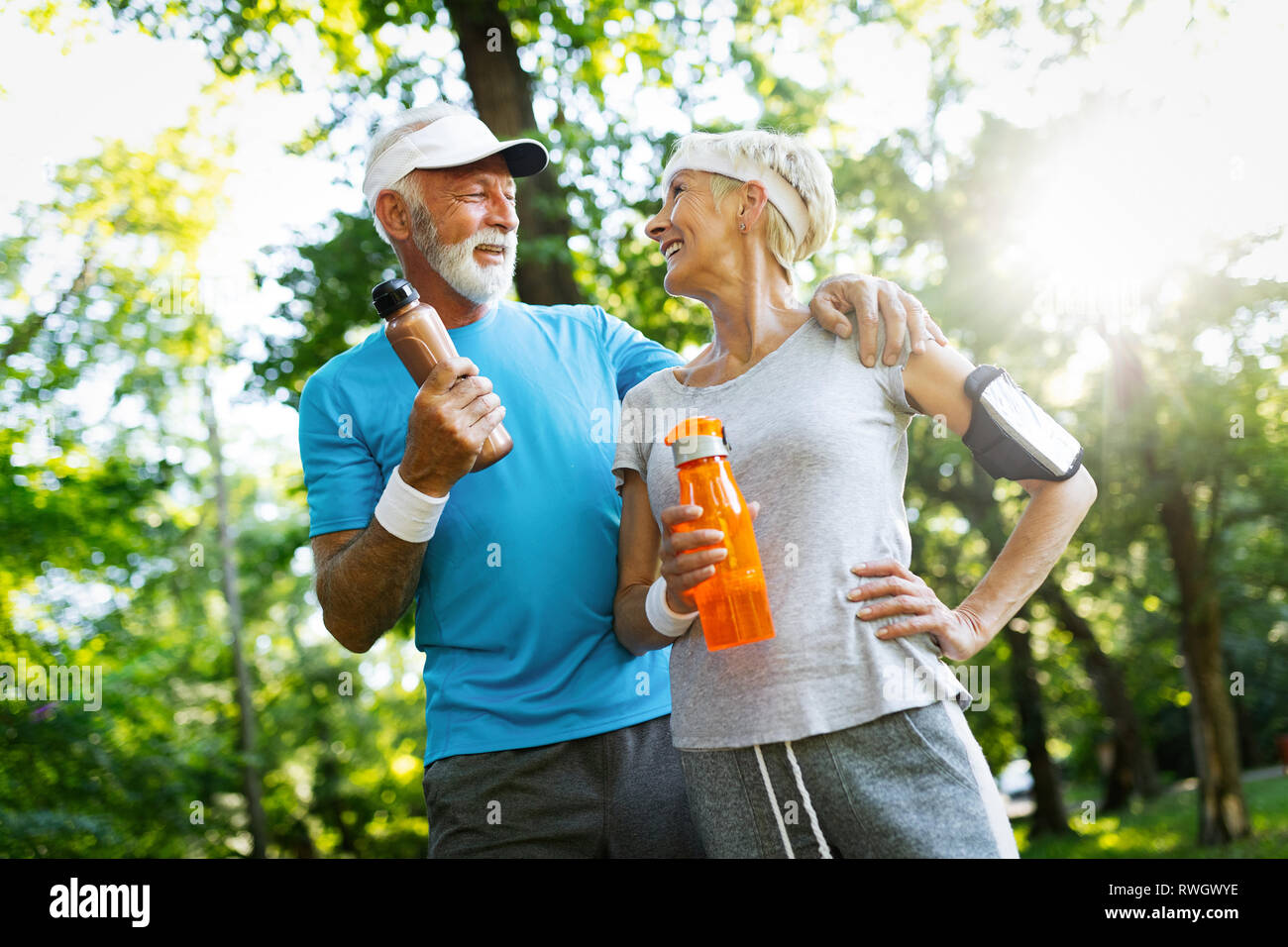 Happy fit senior couple exercising in park Banque D'Images