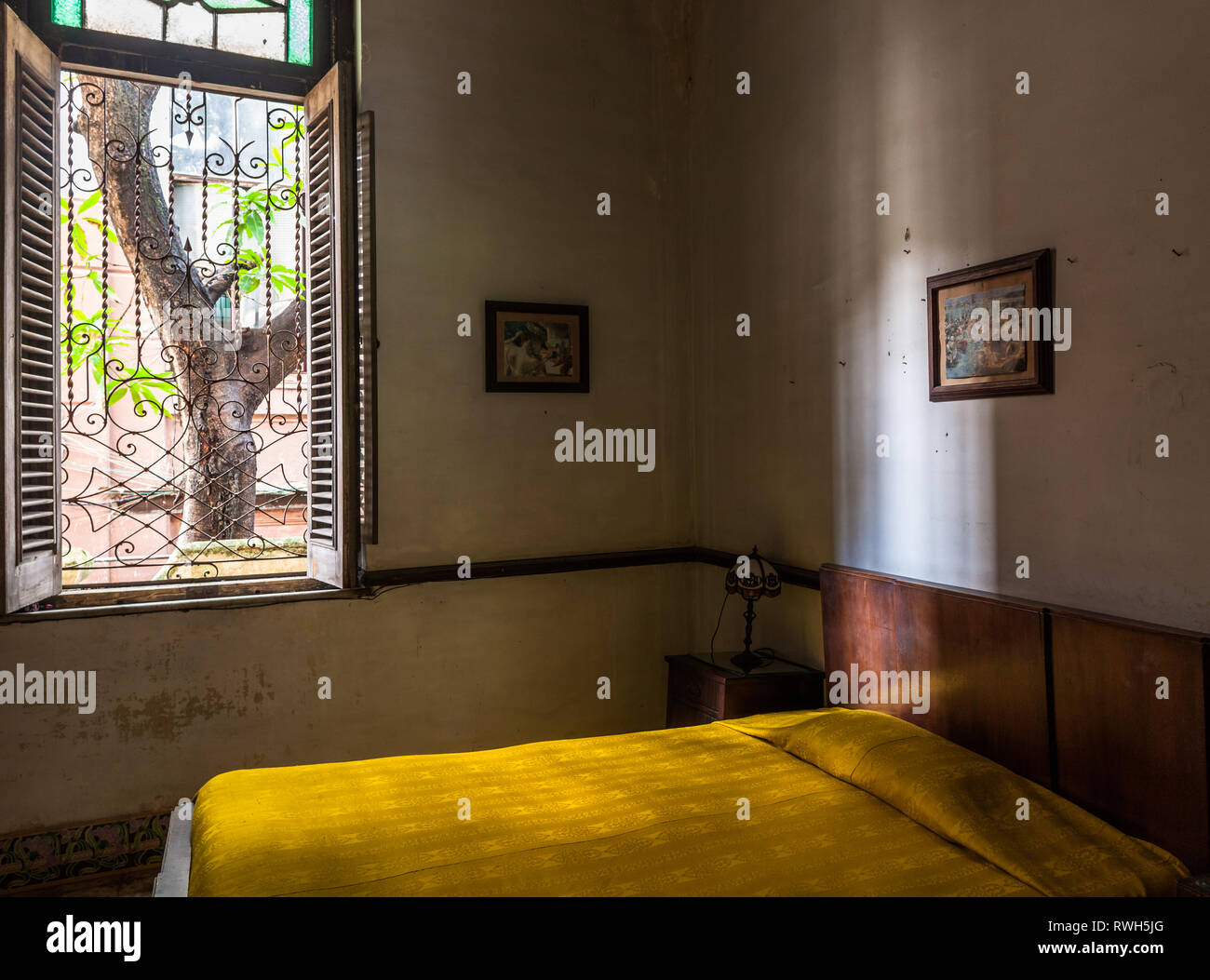 Vedado, La Havane, Cuba. 16 Juin, 2017. Un lit jaune dans une bedroon dans une maison coloniale à Vedado Cuba. Banque D'Images