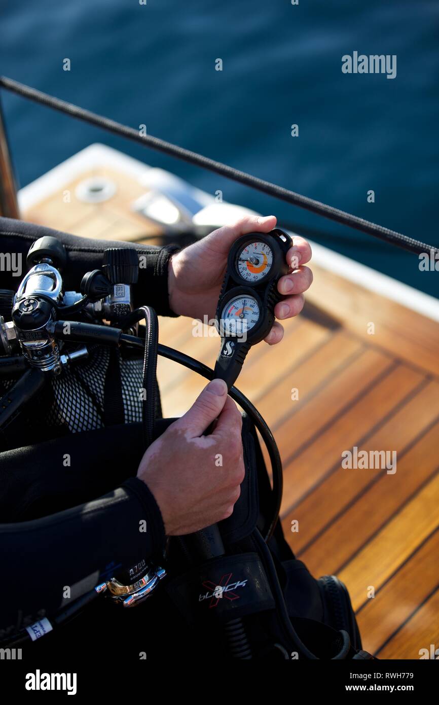 Portrait de plongeur avec le matériel de plongée à bord du bateau, mains tenant régulateur d'oxygène - Contrôles de plongée Banque D'Images