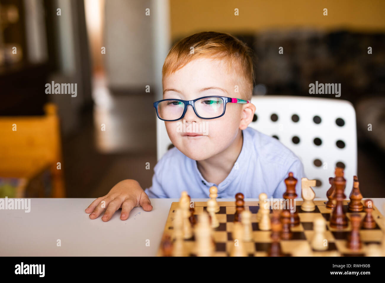 Petit Bebe Garcon Avec Le Syndrome Avec De Grandes Lunettes Bleu Jouant Aux Echecs En Maternelle Photo Stock Alamy