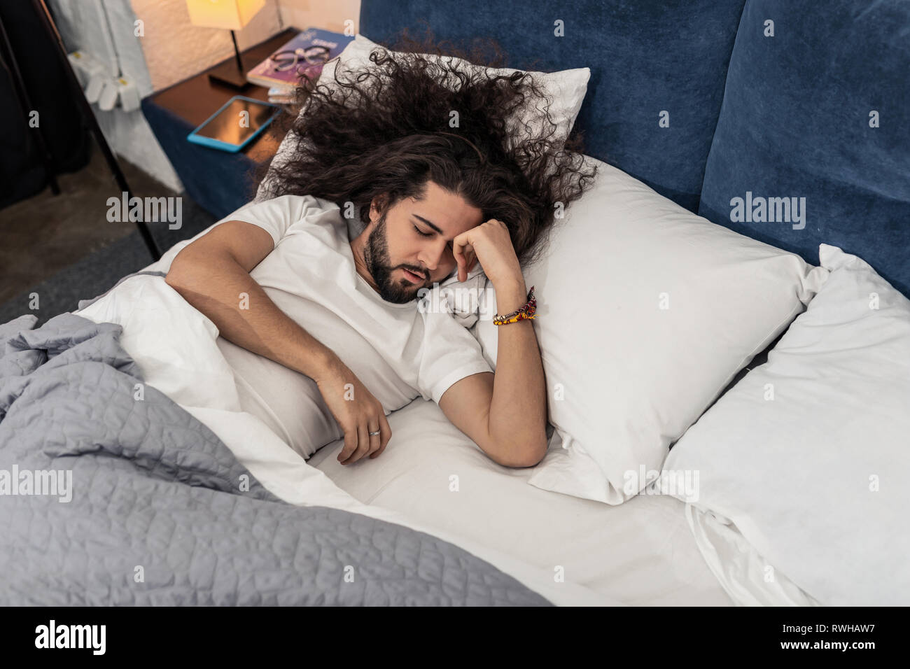 L'homme aux cheveux long belle essaie de dormir Banque D'Images