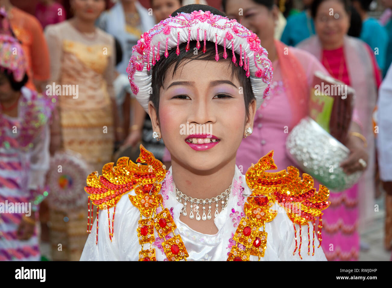Le portrait d'un jeune garçon birman vêtu d'un costume bouddhiste et d'un visage composé de maquillage assiste à sa cérémonie de l'âge à Mandalay au Myanmar Banque D'Images
